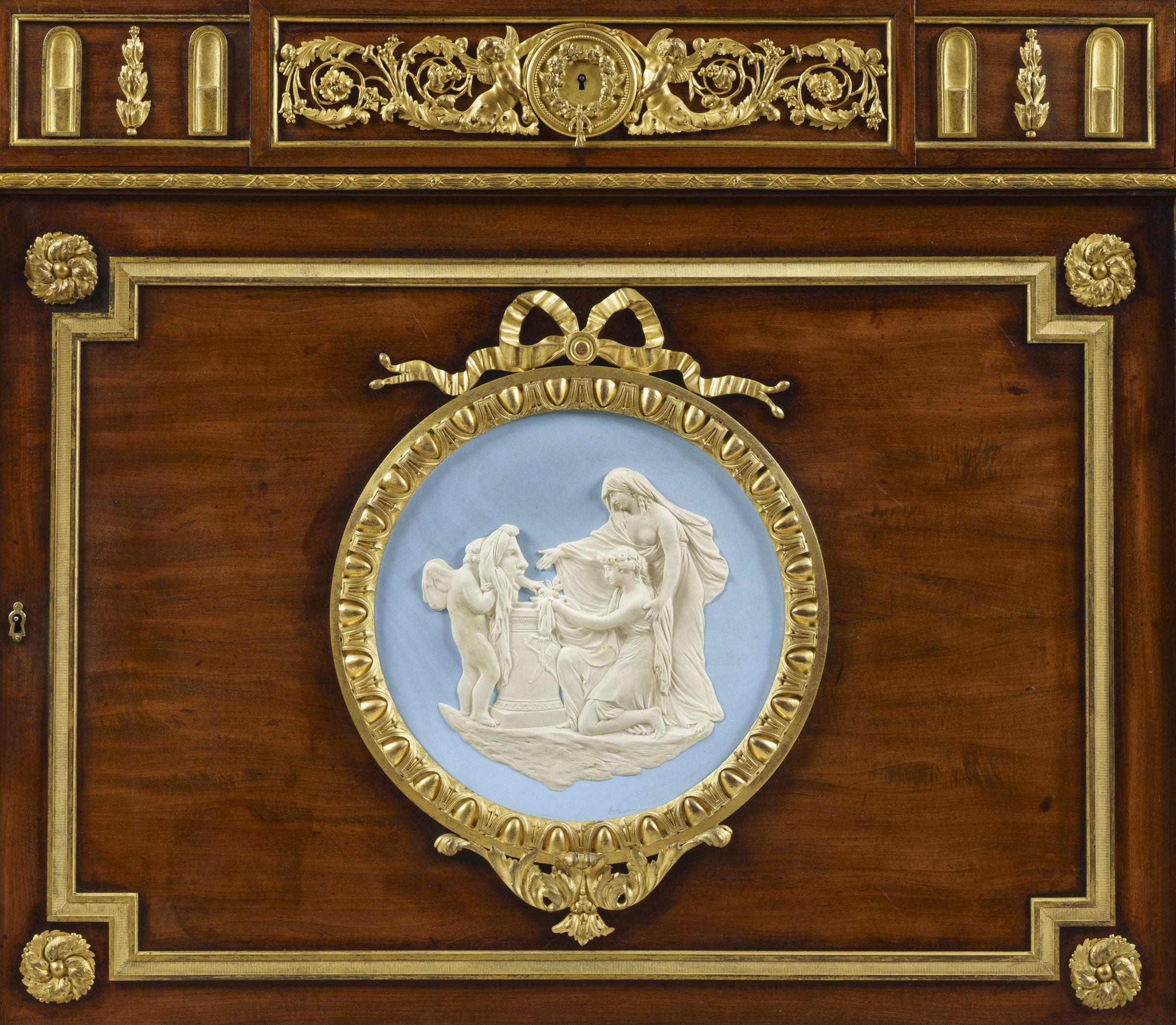 An Ormolu- and Wedgwood Jasperware-Mounted mahogany commode à l'Anglaise
Firmly Attributed to Julius Zwiener

A fine commode an l'anglaise having a shaped marble top inset within a gilt-bronze border, above a frieze applied with finely cast