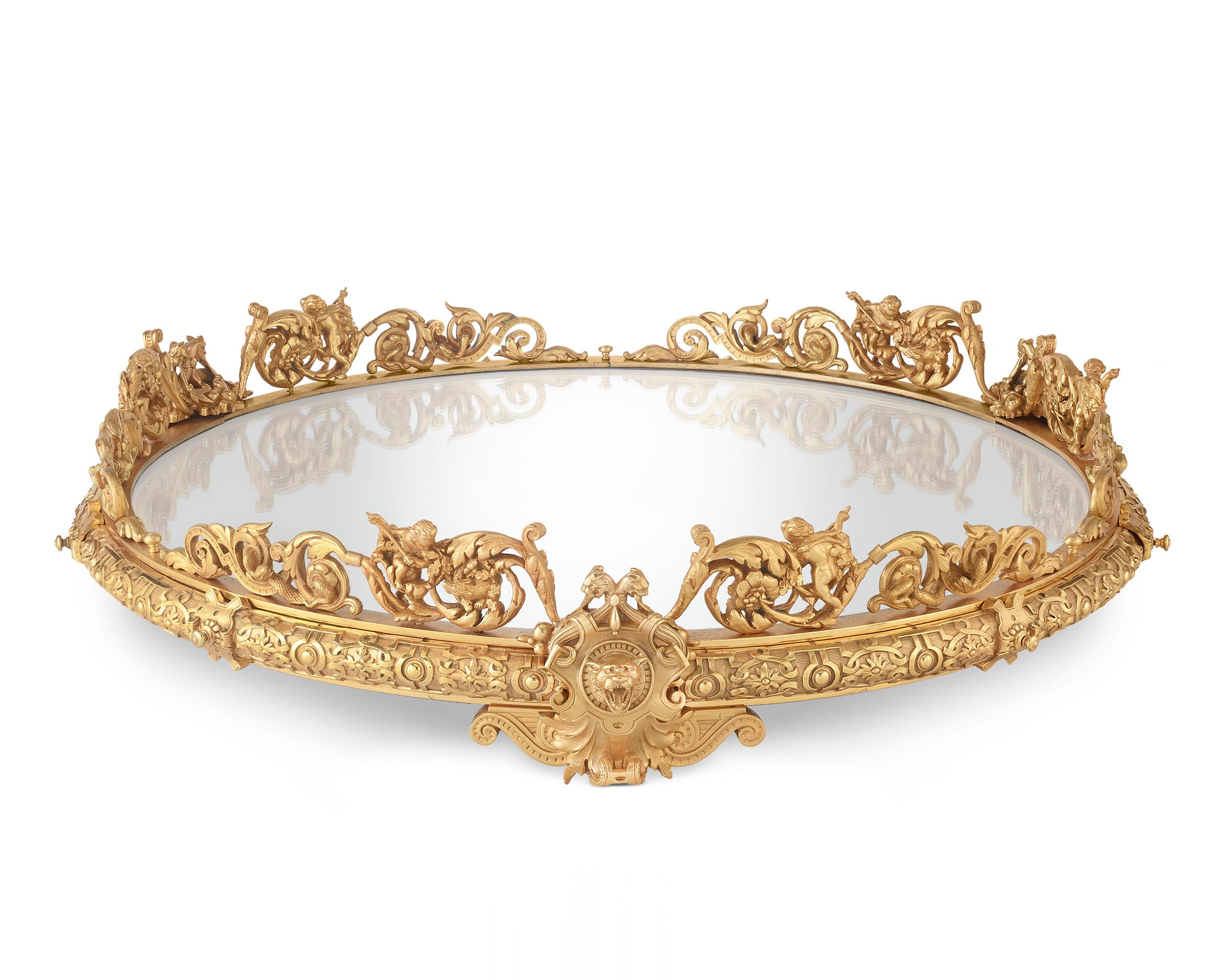 This grand French plateau showcases superb ormolu bronze work. Lavishly decorated with an array of neoclassical decorations including putti, lions' heads and floral accents, the plateau features a mirrored surface for displaying treasured objects