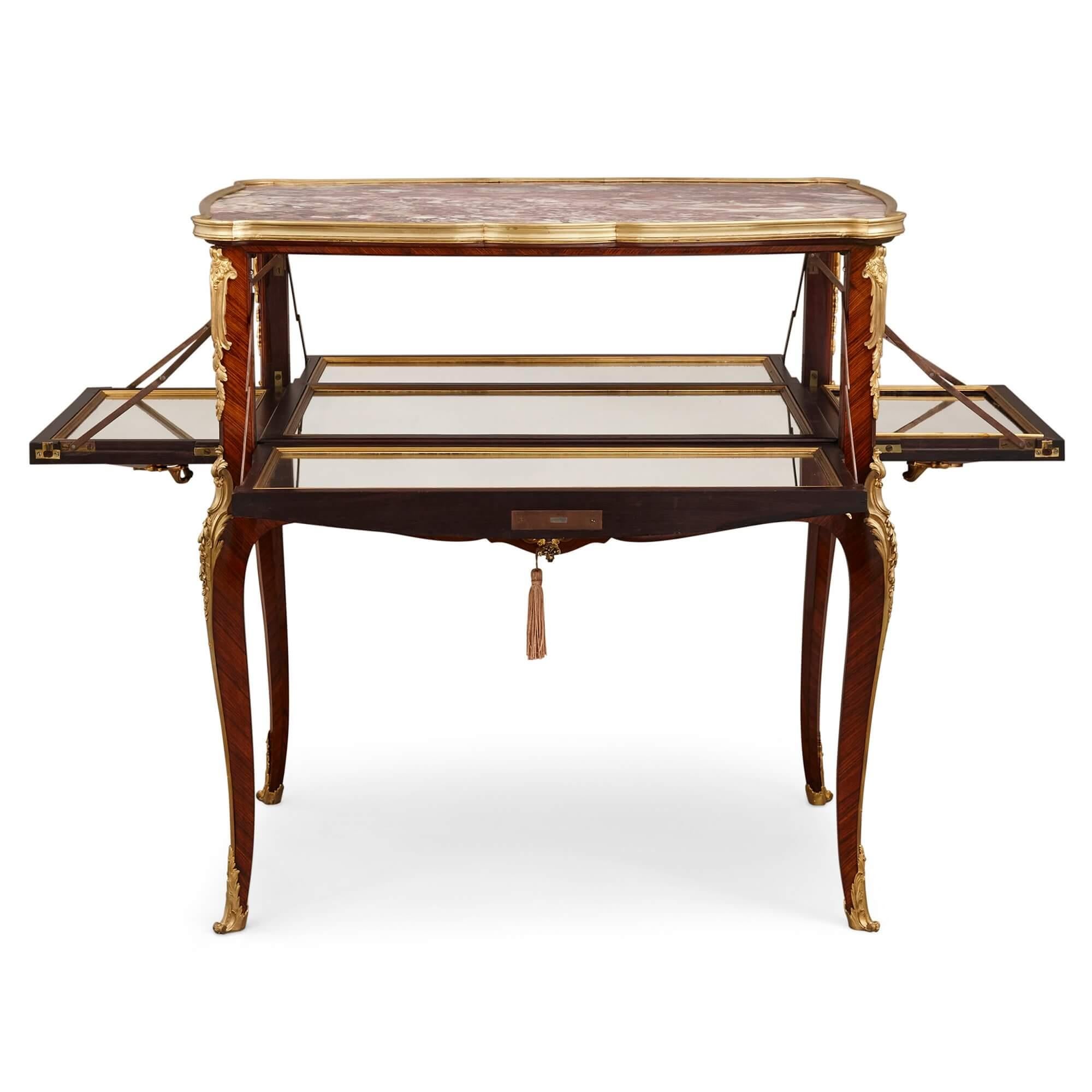 Table d'appoint en ormolu, bois royal, bois satiné et parqueterie de Linke 
France, Fin du 19ème/début du 20ème siècle
Dimensions : Hauteur 86 cm, largeur 81 cm, profondeur 50 cm.

Conçue dans le style Louis XV, cette table est de forme contournée