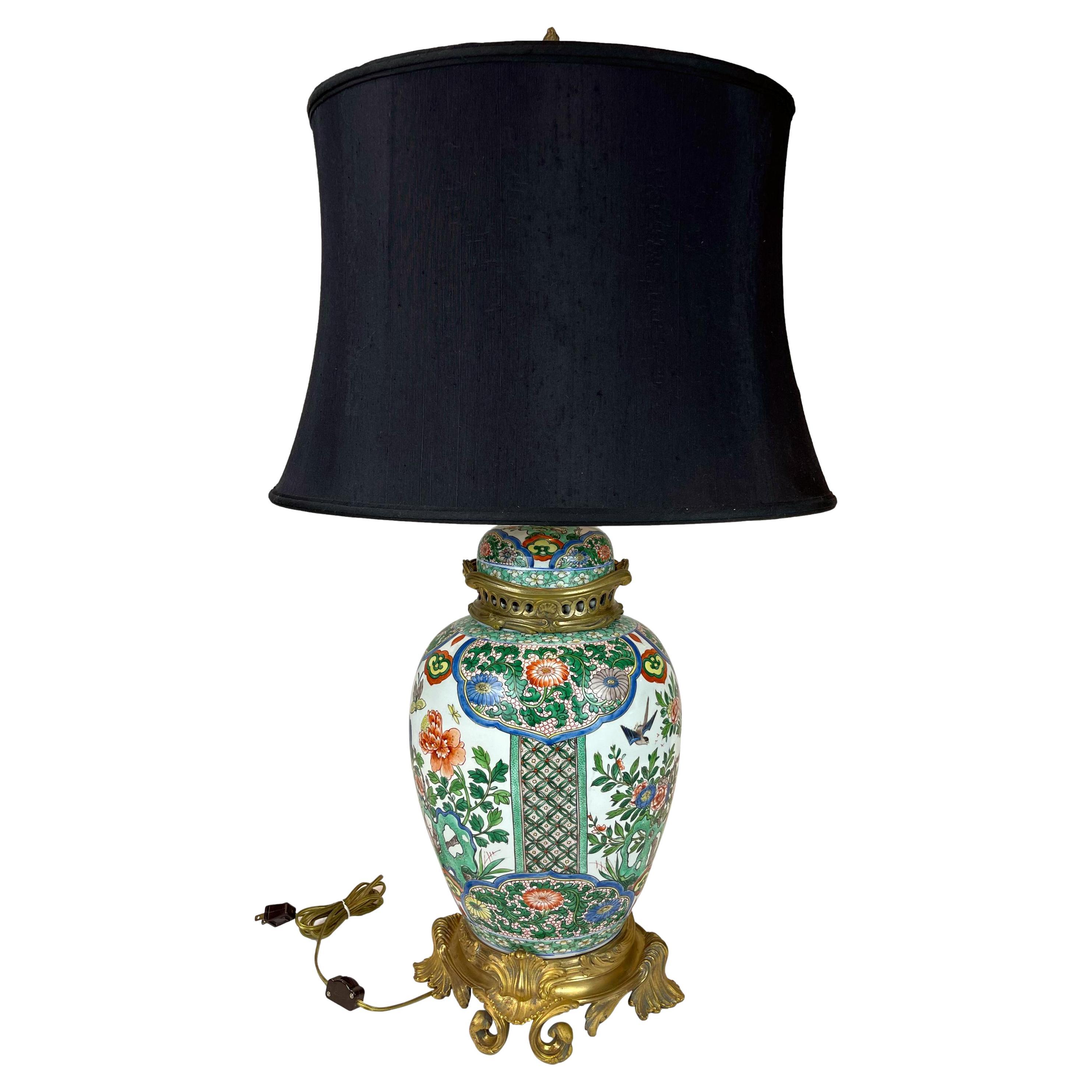 A Chinese Famille rose temple jar and lid, with polychrome enamals depicting a garden pattern with birds and insects, the predominant color being green, ca. 1900; both the lid and base with later French gilded bronze mounts, ca. 1920.
With a new