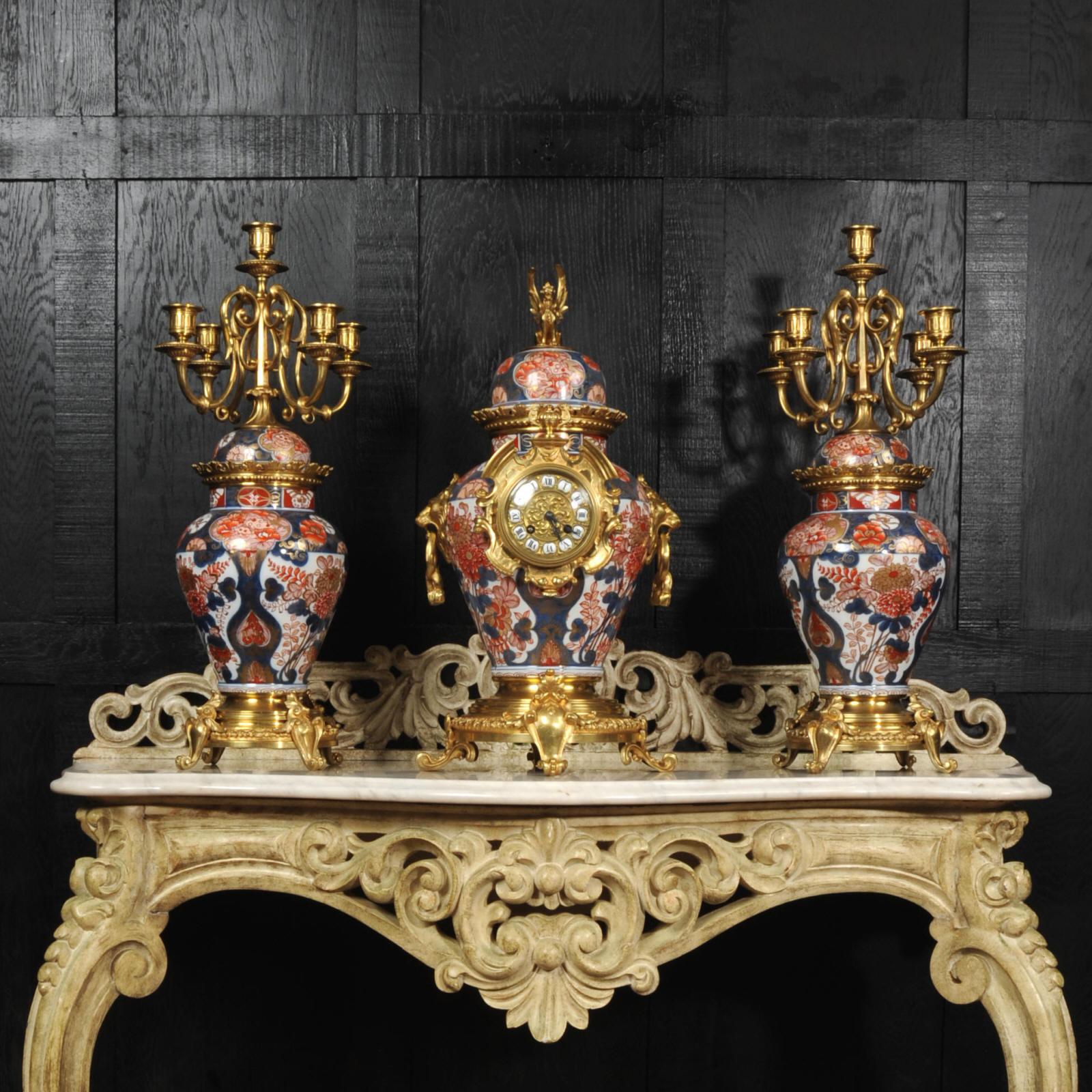 A very large, rare and impressive original antique clock set. The bodies are stunning Japanese Imari Porcelain mounted with finely gilded bronze. Candelabra are formed from a matching pair of Japanese Imari Porcelain jars of inverted pear form