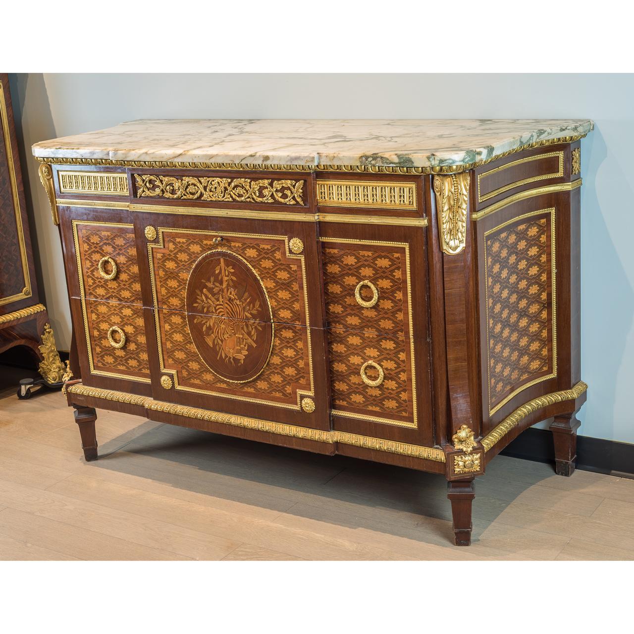 The breakfront shaped white and green marble-top, above a conforming case mahogany paneled front and sides beneath a guilloche and vitruvian scroll frieze. The front parquetry with two long drawers decorated ‘sans traverse’ with an oval reserve