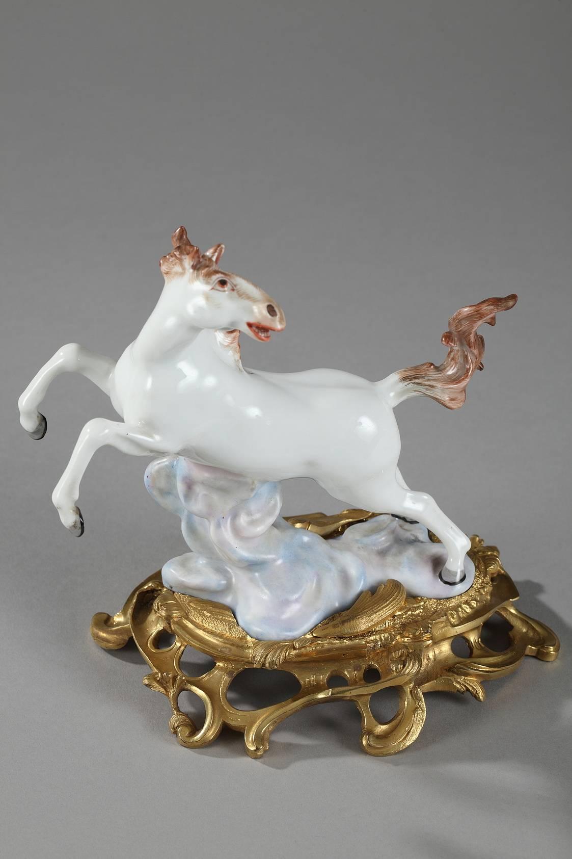 Pair of 20th century white porcelain horses on clouds, above rocaille bases richly decorated with scrollwork and openwork foliage. Both figures are marked underneath with two crossed blue swords, one of the Samson porcelain factory’s most famous