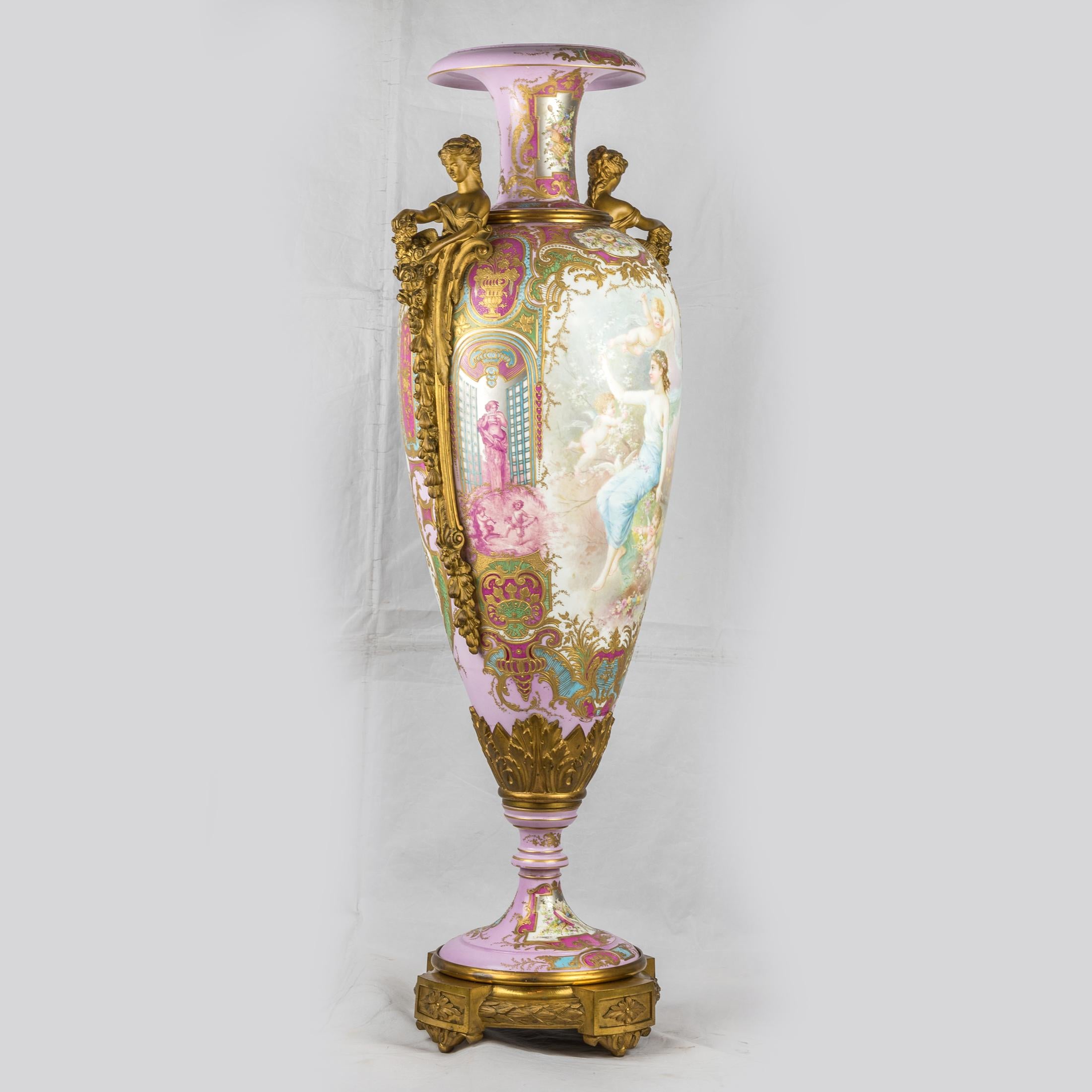 Very fine quality gilt bronze mounted Sèvres-style pink-ground vase with elongated shield shape, painted with a maiden and cupids with arrows in the garden, within a pale-blue and gilt scrollwork surround, the reverse with a landscape, streams and