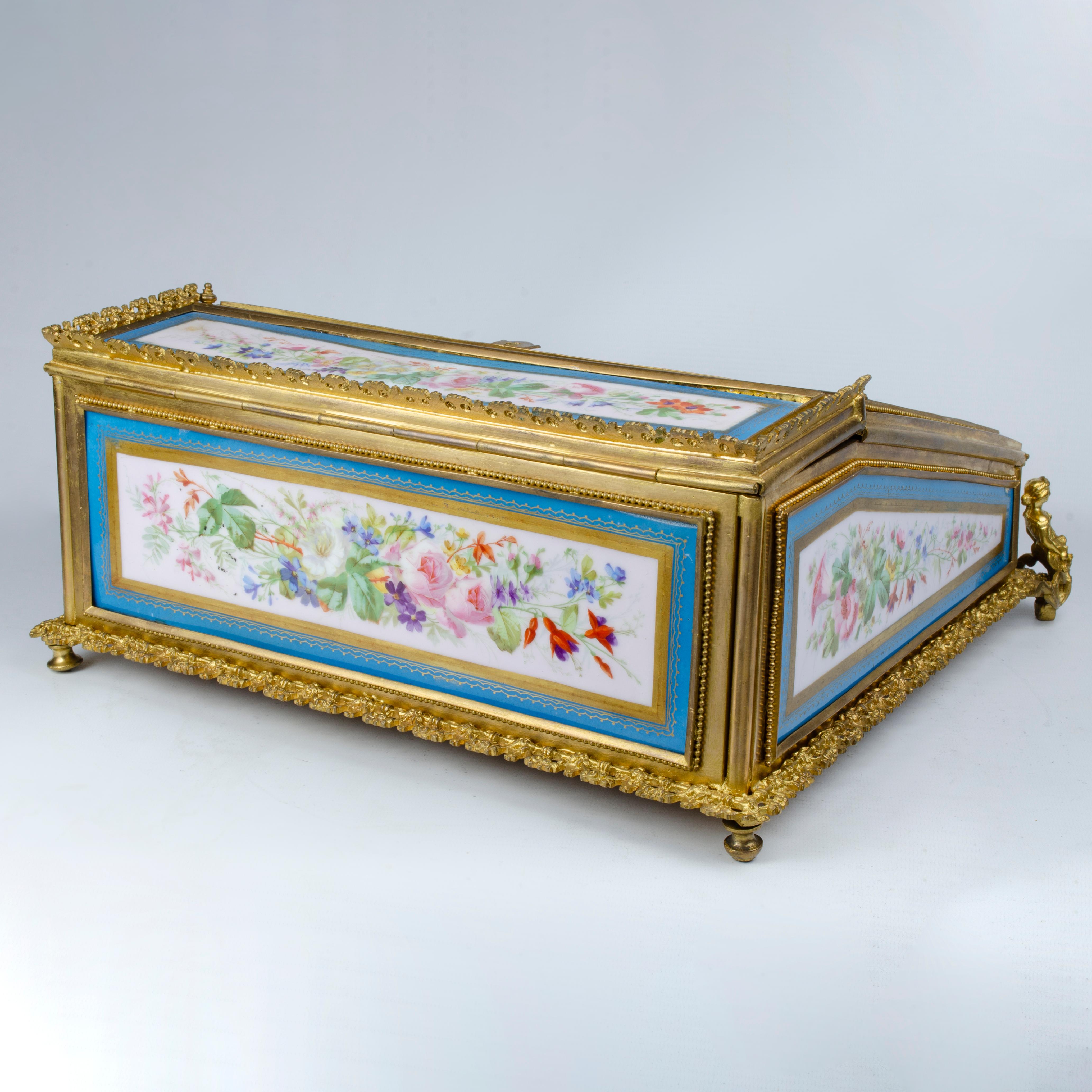 Travel desk made with Sevres style porcelain plates, with mercury gold plated bronze mount. The piece is in a late 19th century Napoleon III style.
The upper part is inclined and has a painting with a design corresponding to a period after the