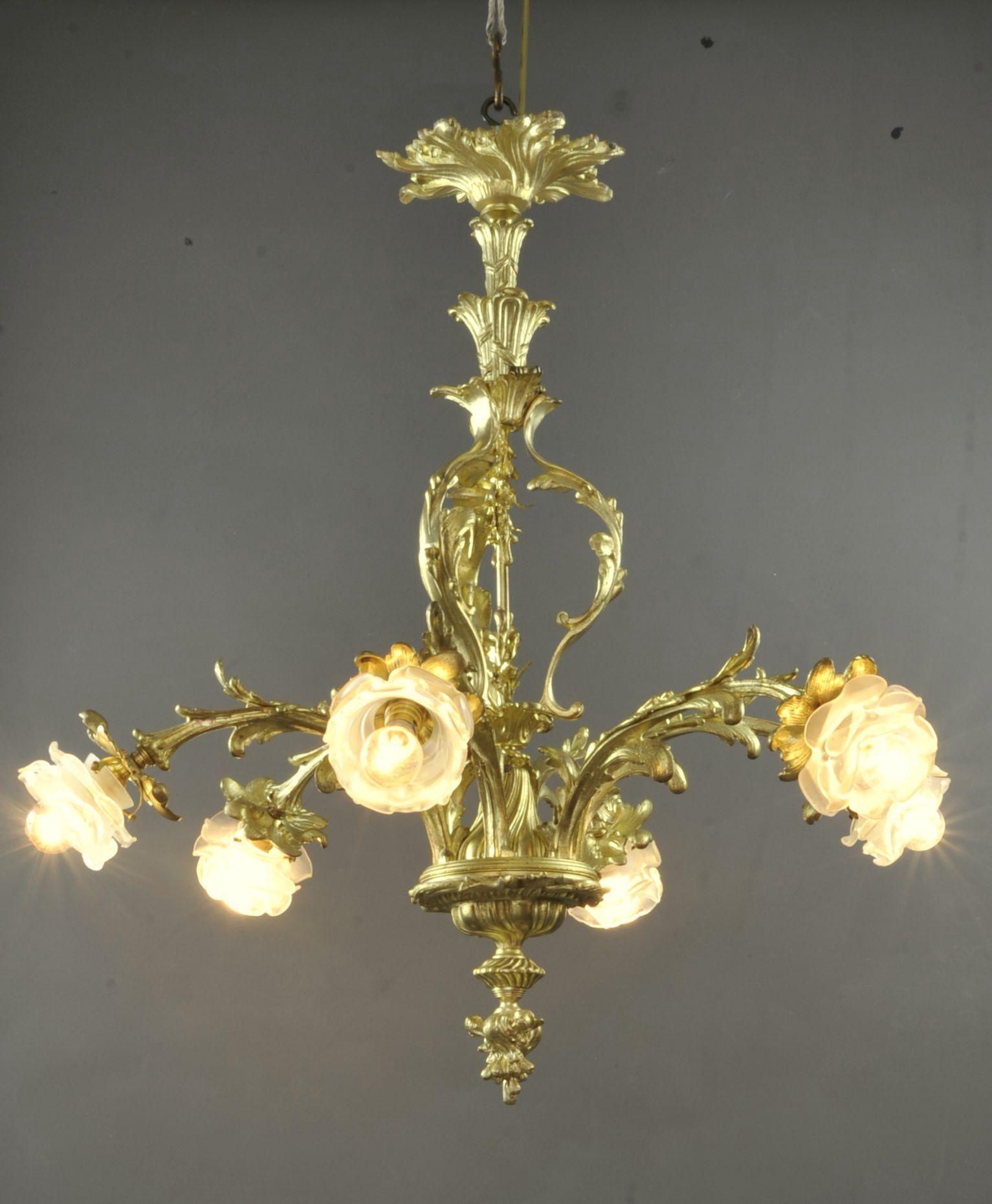 Magnificent Napoleon III chandelier in gilded and chiseled bronze with rich vegetal decoration, with turbulent shapes of rocaille inspiration, lighting with 6 arms of light ending in a frosted glass tulip in the shape of a rosebud.

French work