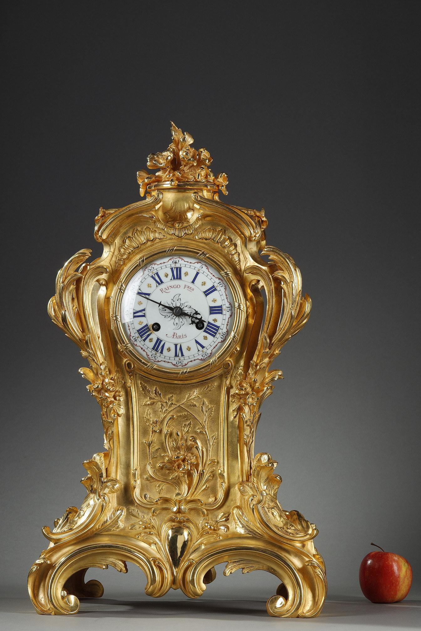 Important Rococo style clock in chased and gilt bronze. This Louis XV style clock has a very fine decoration of moving foliage, flowers and shells. The whole is surmounted by a bouquet of flowers. The four cambered feet are decorated with portraits