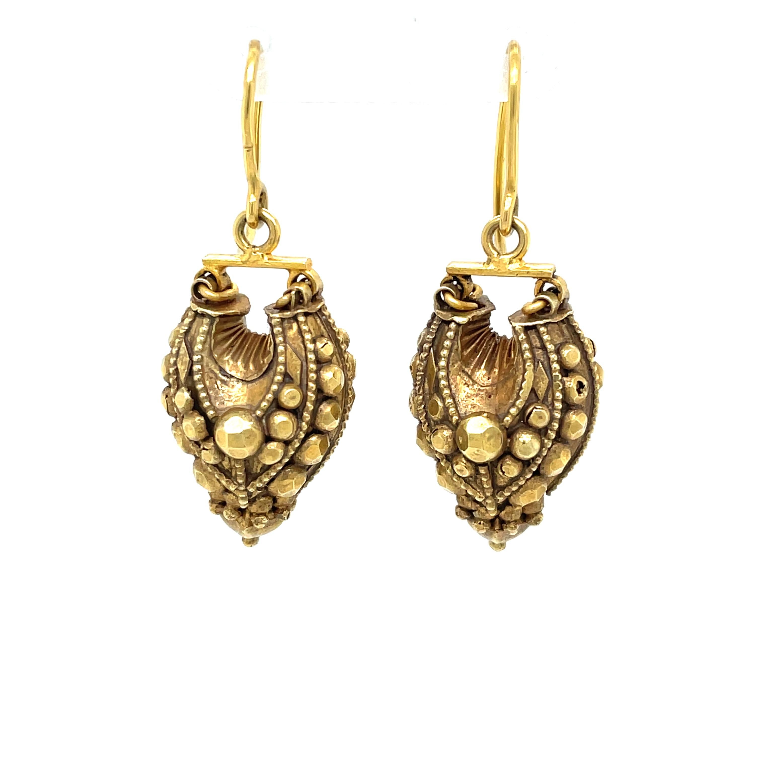 Artfully intricate details beautifully encircle the 14 karat gold elongated bulb that creates each drop on this earring pair. 
The antique gold patina, shows off the dimensional relief cut and ornate design that enhance the 7/8 inch puff style