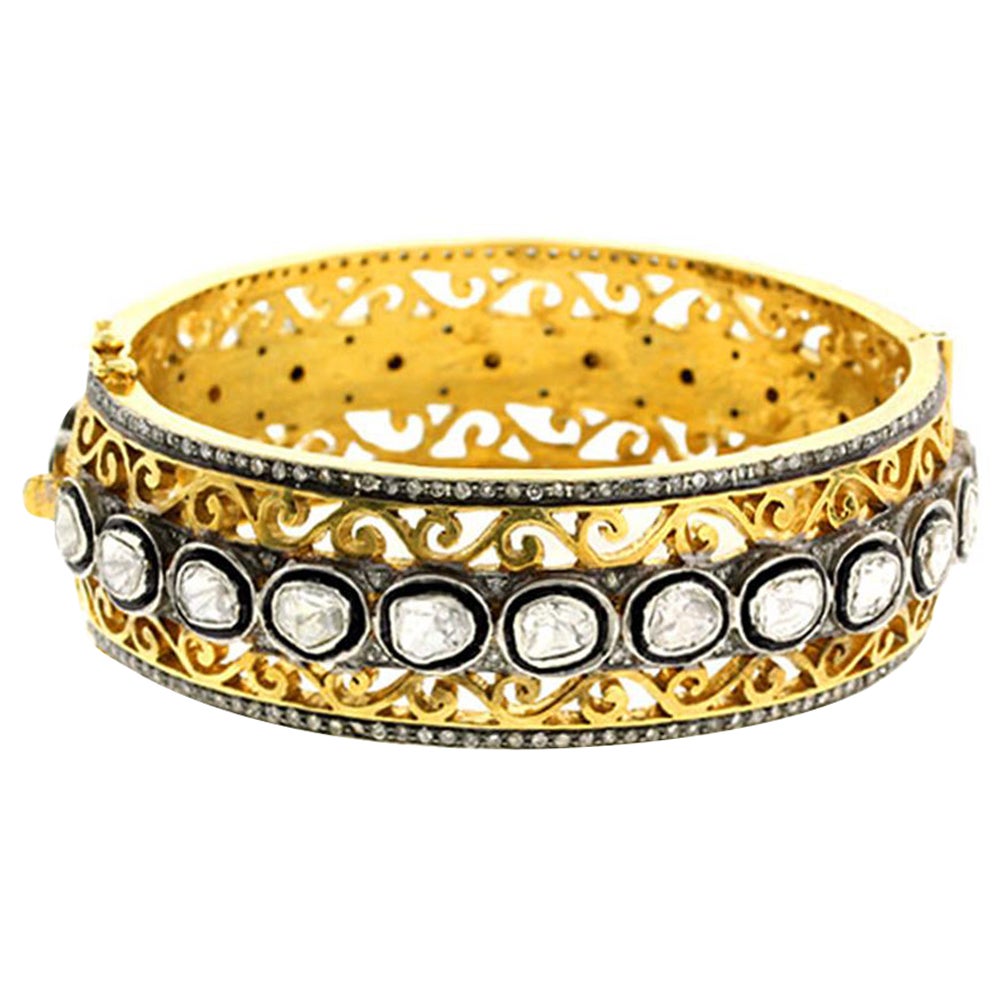 Goldarmreif mit Ornamental Design und Diamanten umgeben von Diamanten in Pavé-Fassung