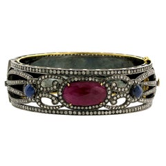 Bangle dal design ornamentale con zaffiro rubino e pavé di diamanti in oro e argento 18k