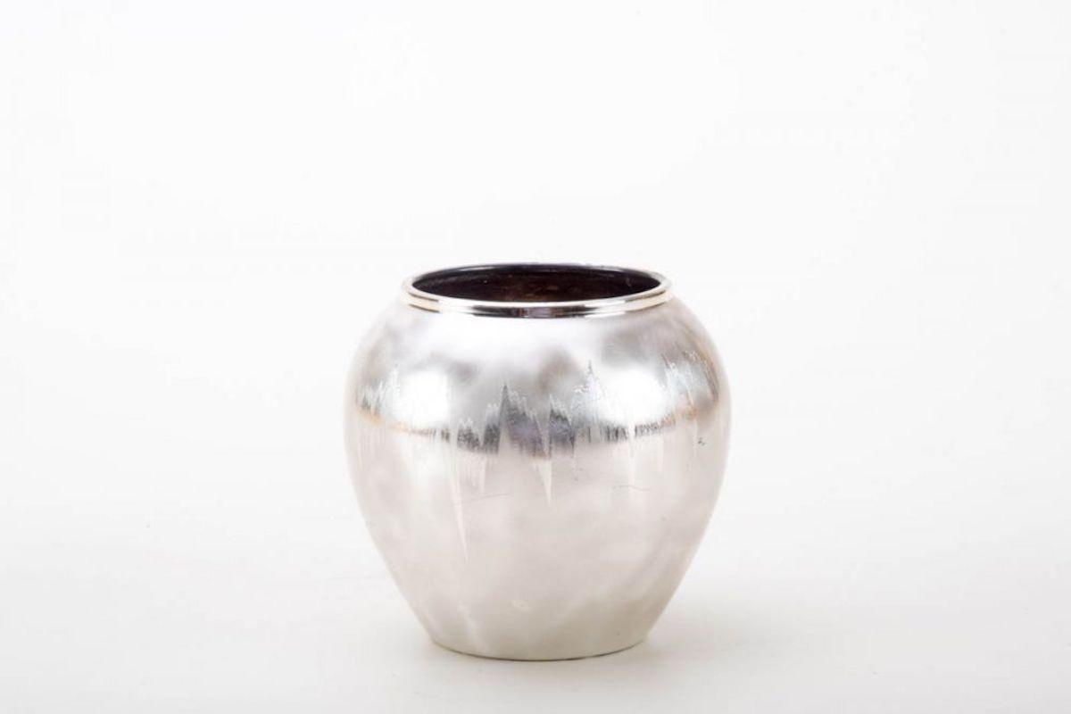 Ornamental Ikora vase is an original decorative object realized in the first half of the 20th century.

Our specimen is a metal vase refined in the NKA process, with a pleasant spherical body, a cloudy background with a shiny ray motif. Made by