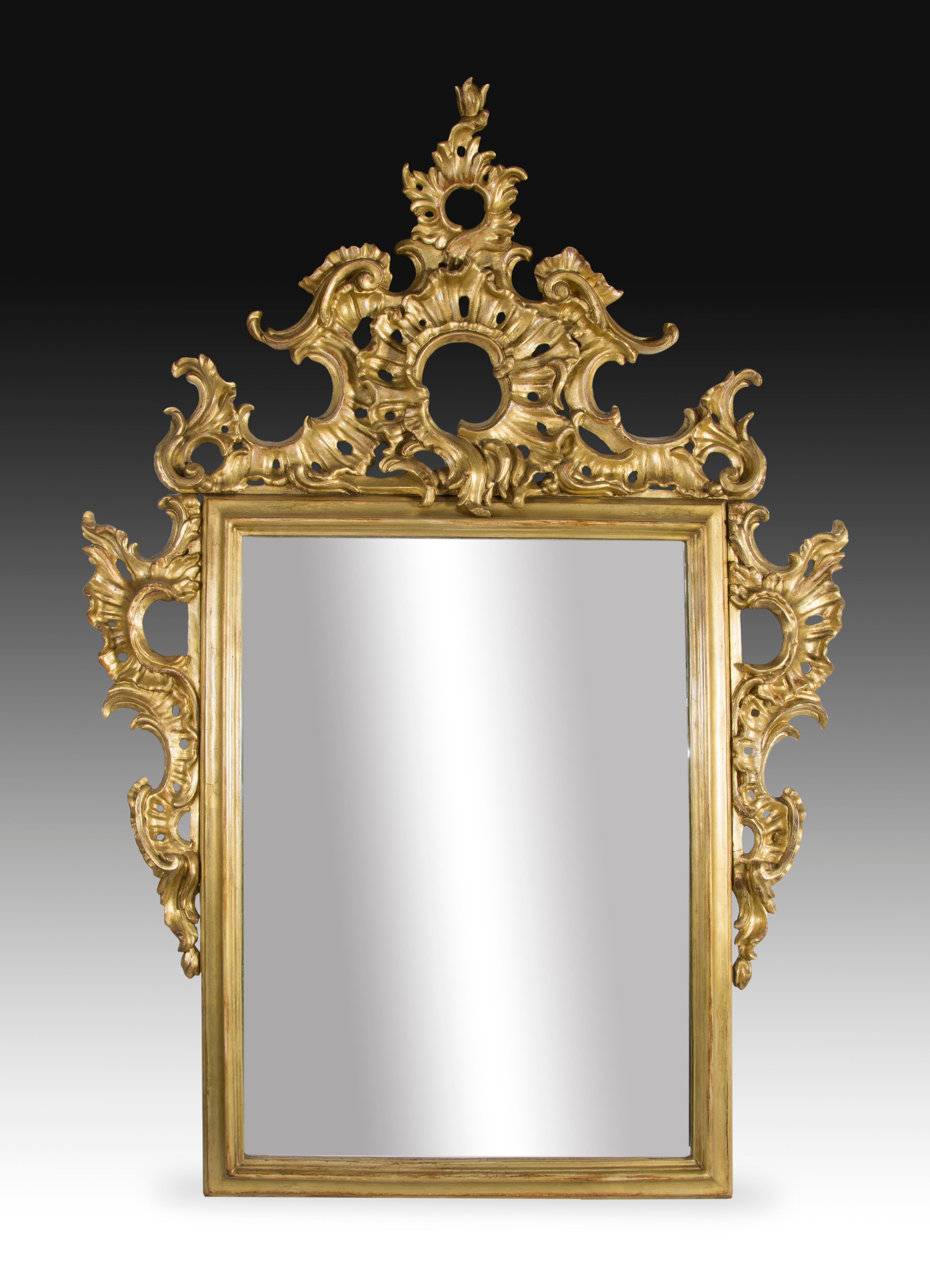 Füllhorn, geschnitztes und vergoldetes Holz, 19. Jahrhundert.
Rechteckiger Spiegel mit einem Rahmen, der durch eine sich an den Seiten erstreckende Cupete hervorgehoben wird. Dieses Exemplar ist mit Schnörkeln und Raketen gestaltet, die sich direkt