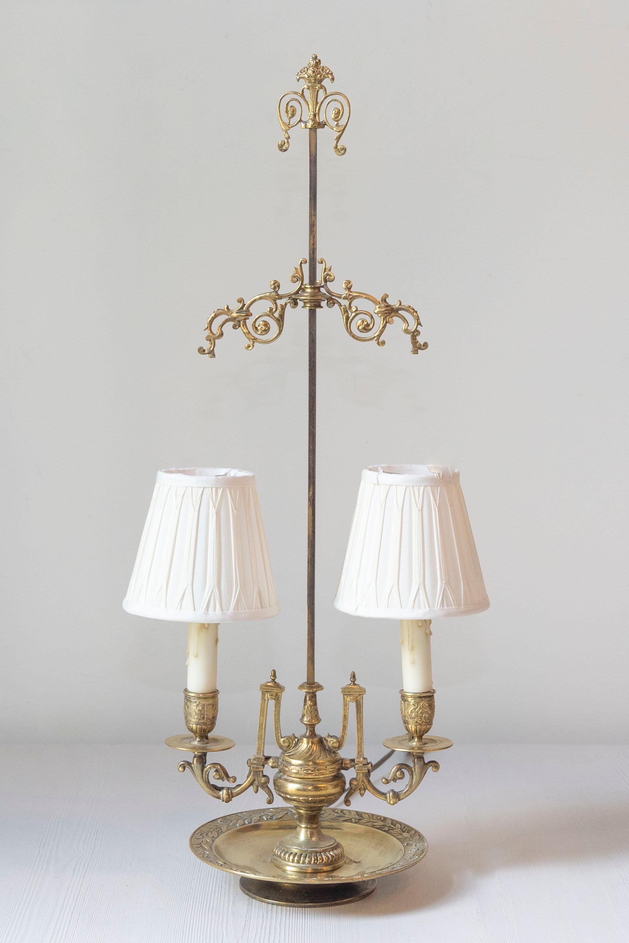 Cette lampe française du XIXe siècle est un exemple remarquable d'artisanat élaboré et de design orné. La lampe est dotée d'une tige centrale haute et fine, ornée de volutes complexes et de fleurons décoratifs, ce qui lui confère un aspect grandiose
