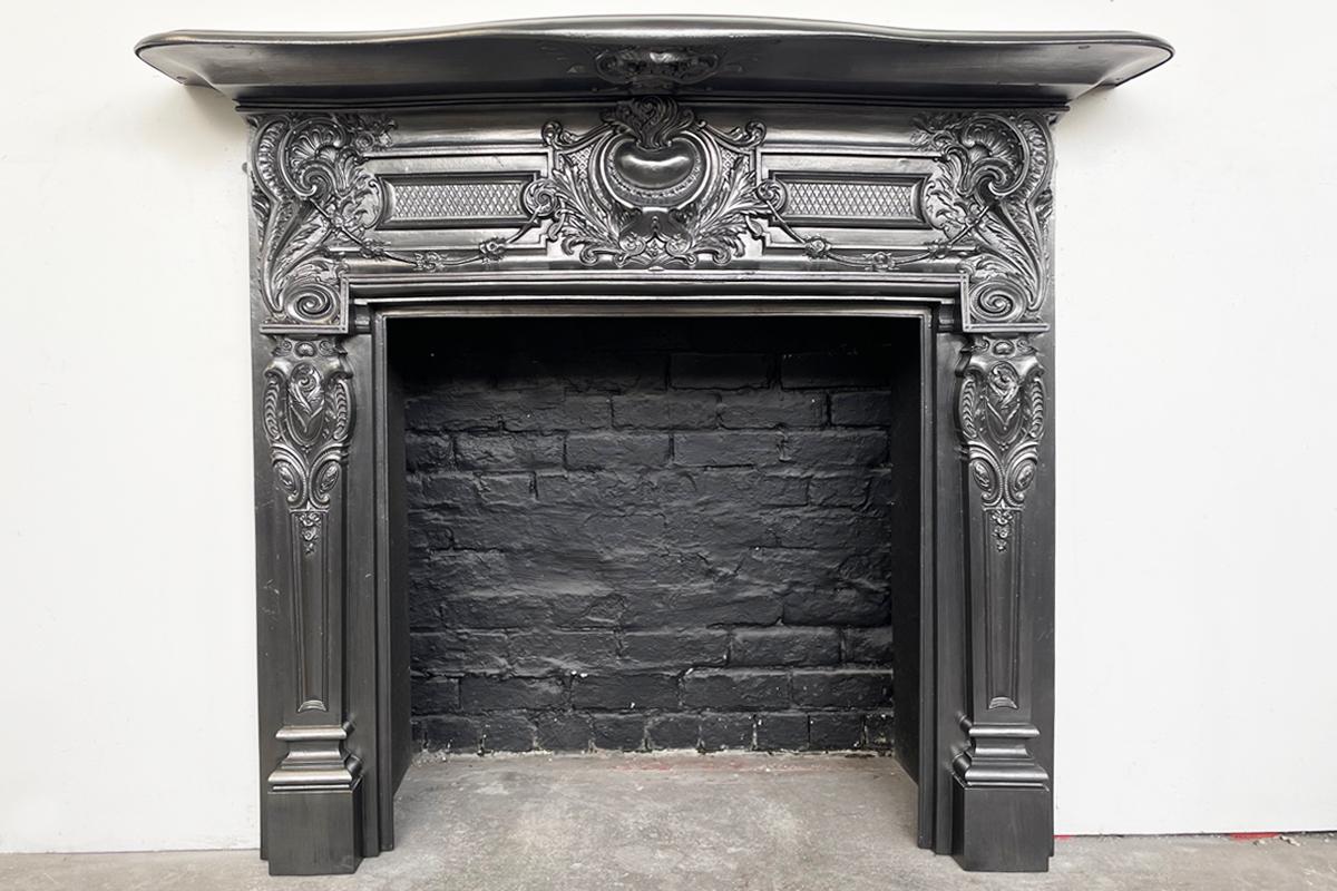 A highly decorative antique late Victorian cast iron fireplace surround in the Roccoco manner. Cira 1875.

Finished with traditional black grate polish. For detailed sizes please see the size diagram in the image gallery.