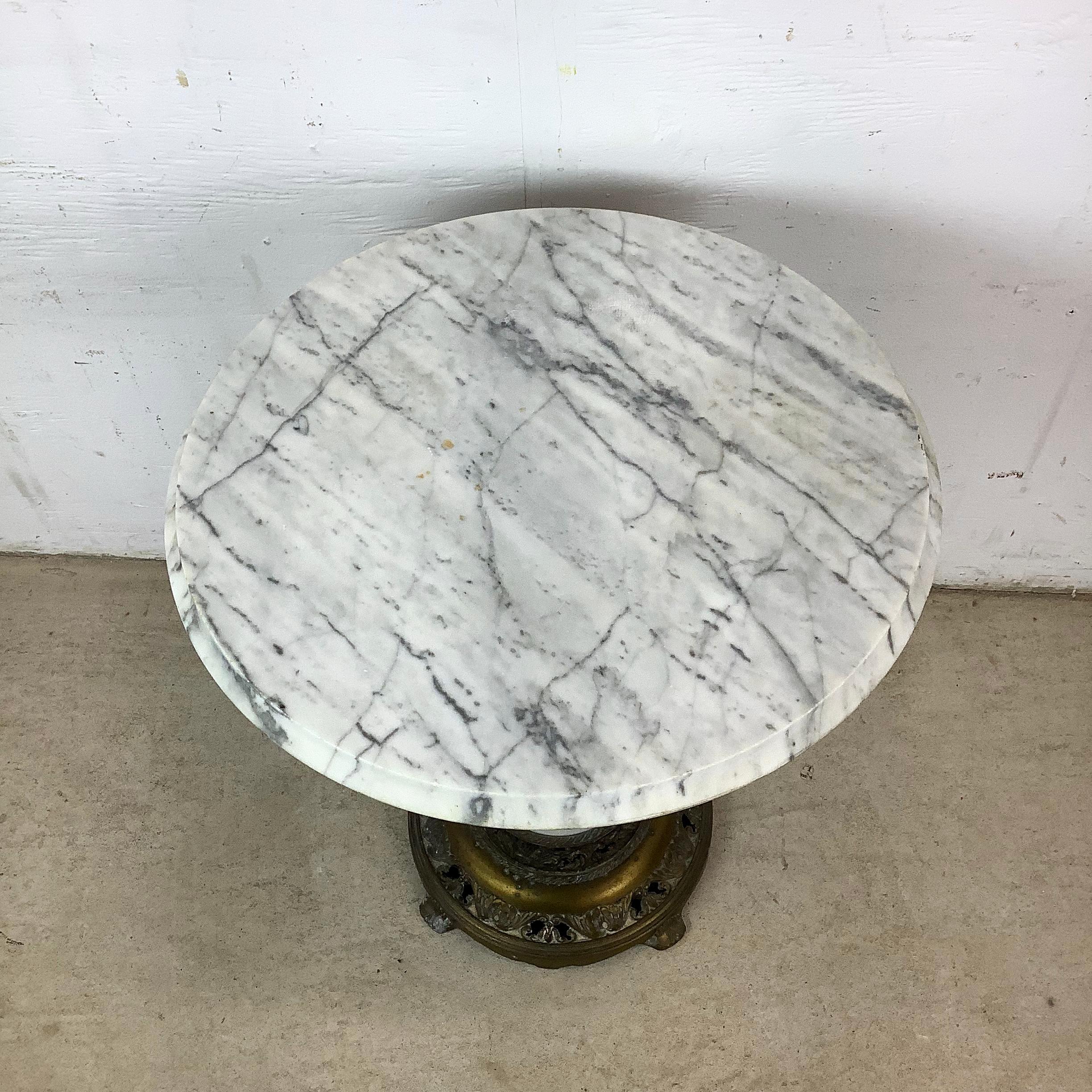This round marble side table is a lovely example of Italianate Revival style filtered through mid-century design sensibilities. The marble top offers a polished, refined surface with natural veining that lends depth and visual movement. Its