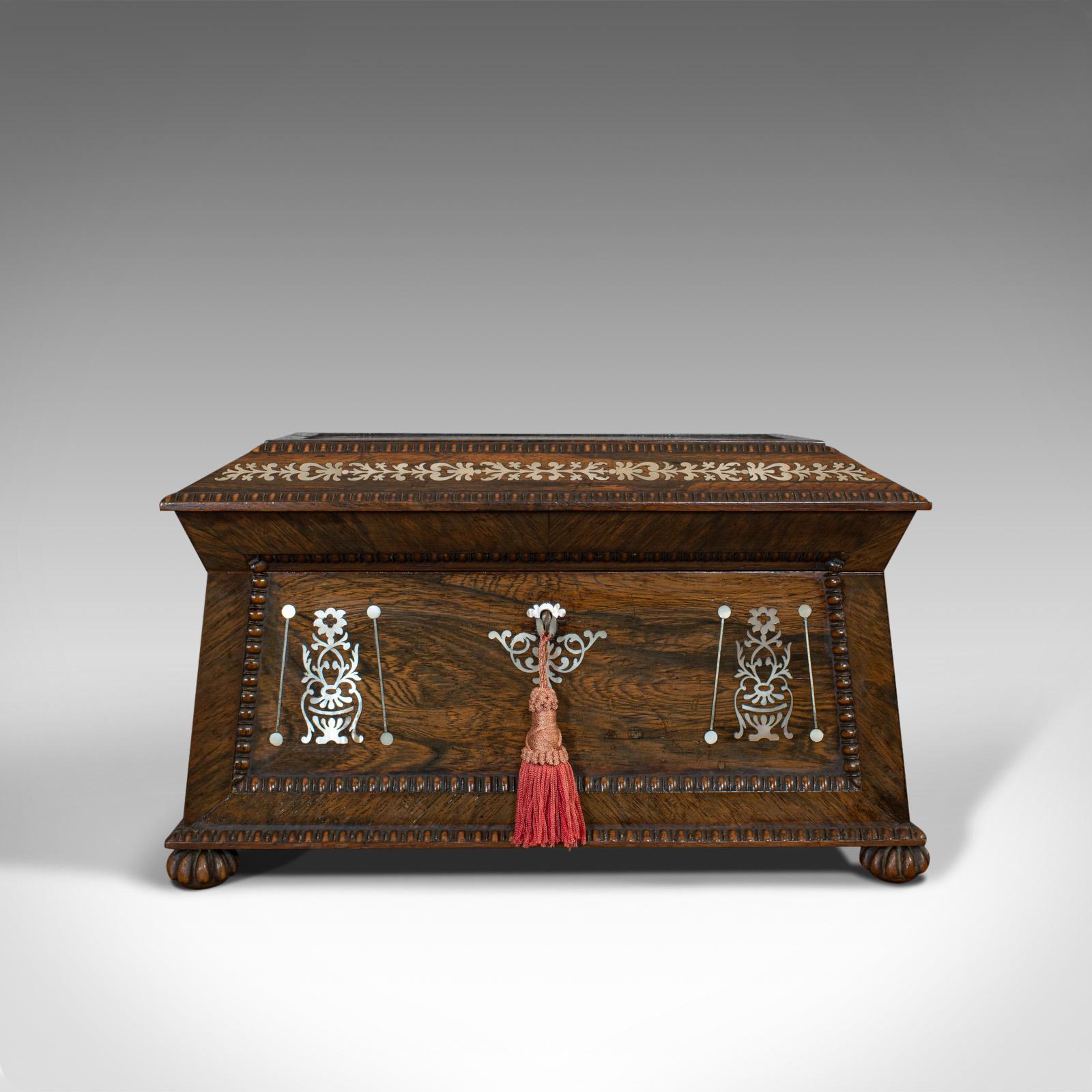 This is an ornate antique tea caddy. An English, rosewood sarcophagus chest with mother of pearl inlay, dating to the Regency period, circa 1820.

Make tea drinking an event with this beautiful caddy
Displays a desirable aged patina
Superb grain