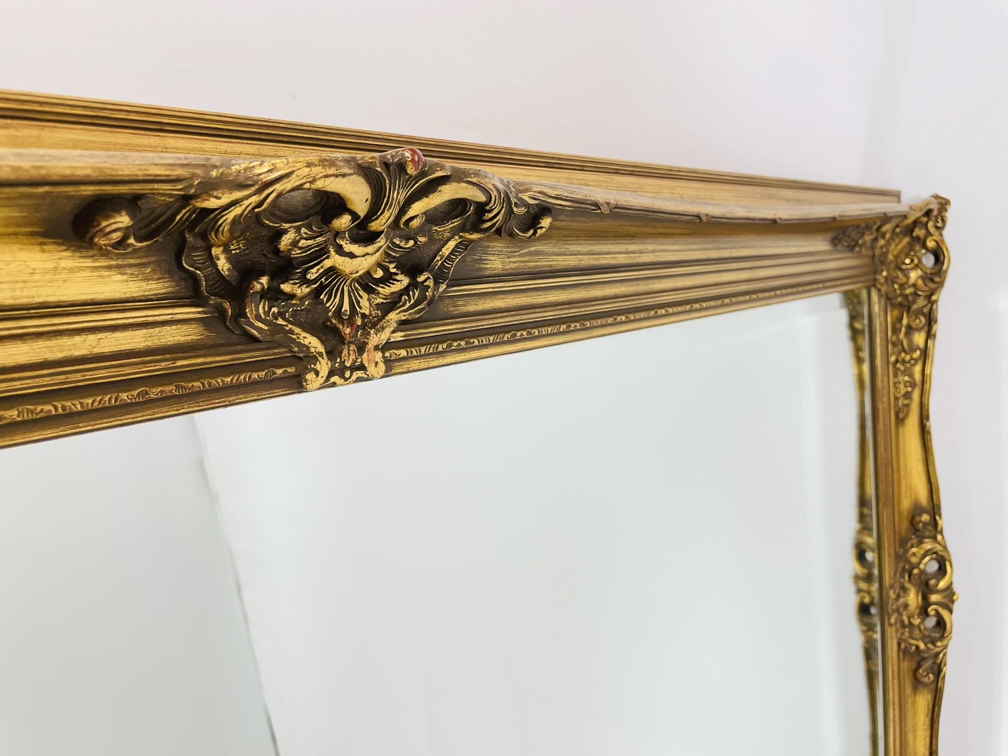 Espejo ornamentado de madera dorada belga con detalles florales rococó, Siglo XX en venta 1