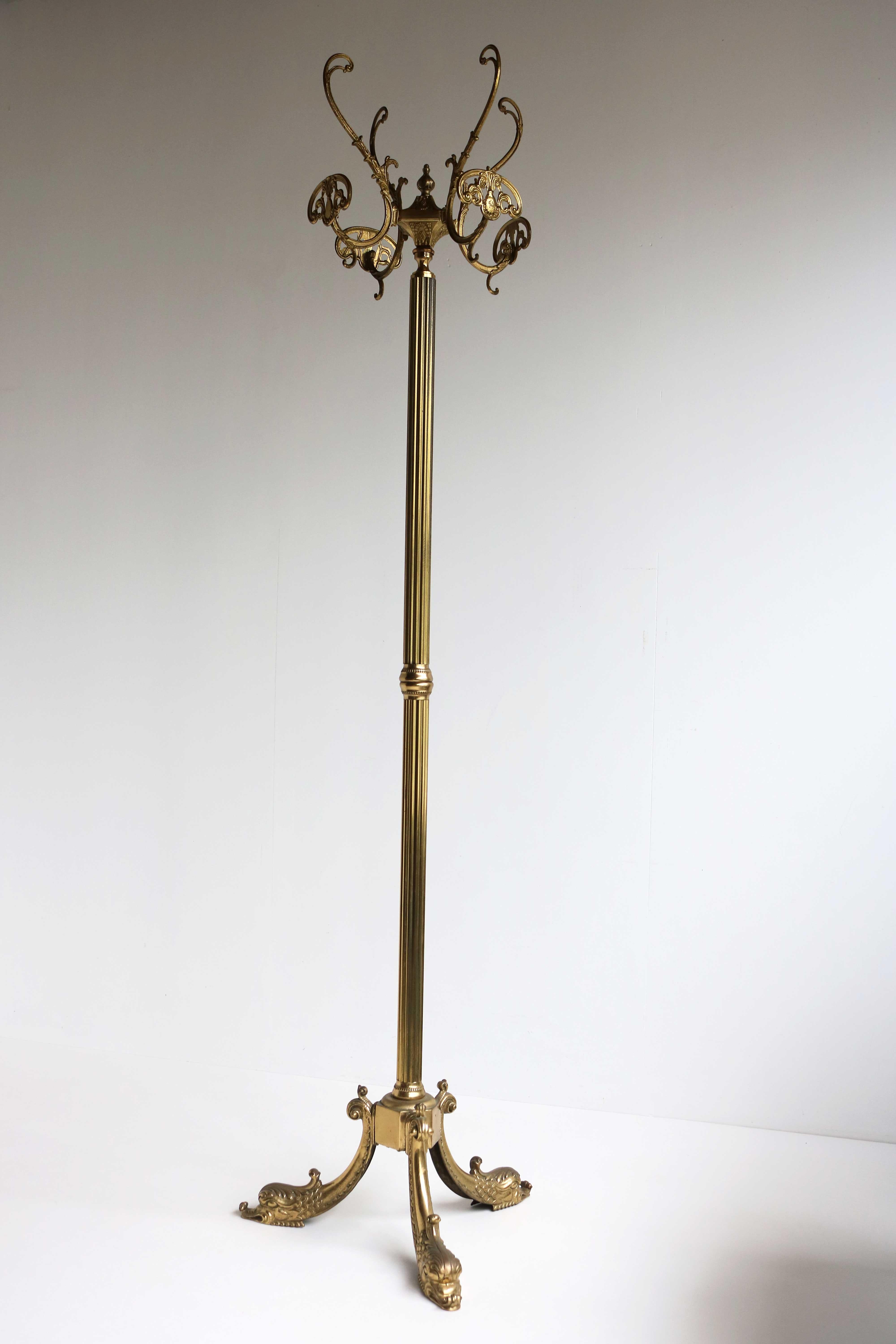 1960s Italian midcentury Hollywood Regency Style Neoclassical brass floor coat hanger swivel four-hook hall tree stand dolphin standing coat hat rack.

This beautiful vintage ornate hall tree dates to the 1960s, It is crafted from brass and has