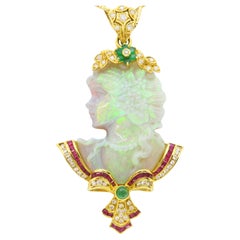 Ornate Carved Opal Pendant set into 18k Gold, with Diamonds, Rubies, and Emerald