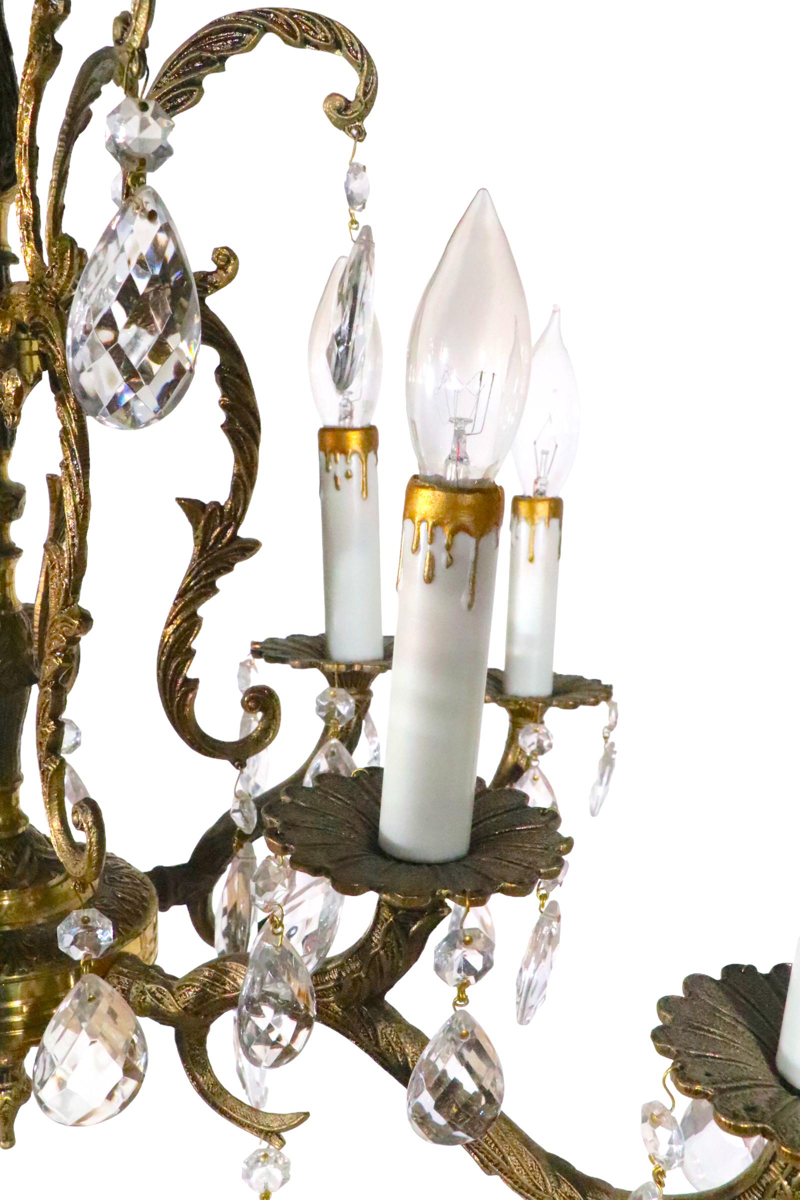 Exceptional 10 light chandelier, constructed of cast brass, dressed  with its original faceted glass crystals.  The chandelier features 10 candle bulbs, with an interior ring and a surrounding outer ring of lights. The fixture is in excellent,