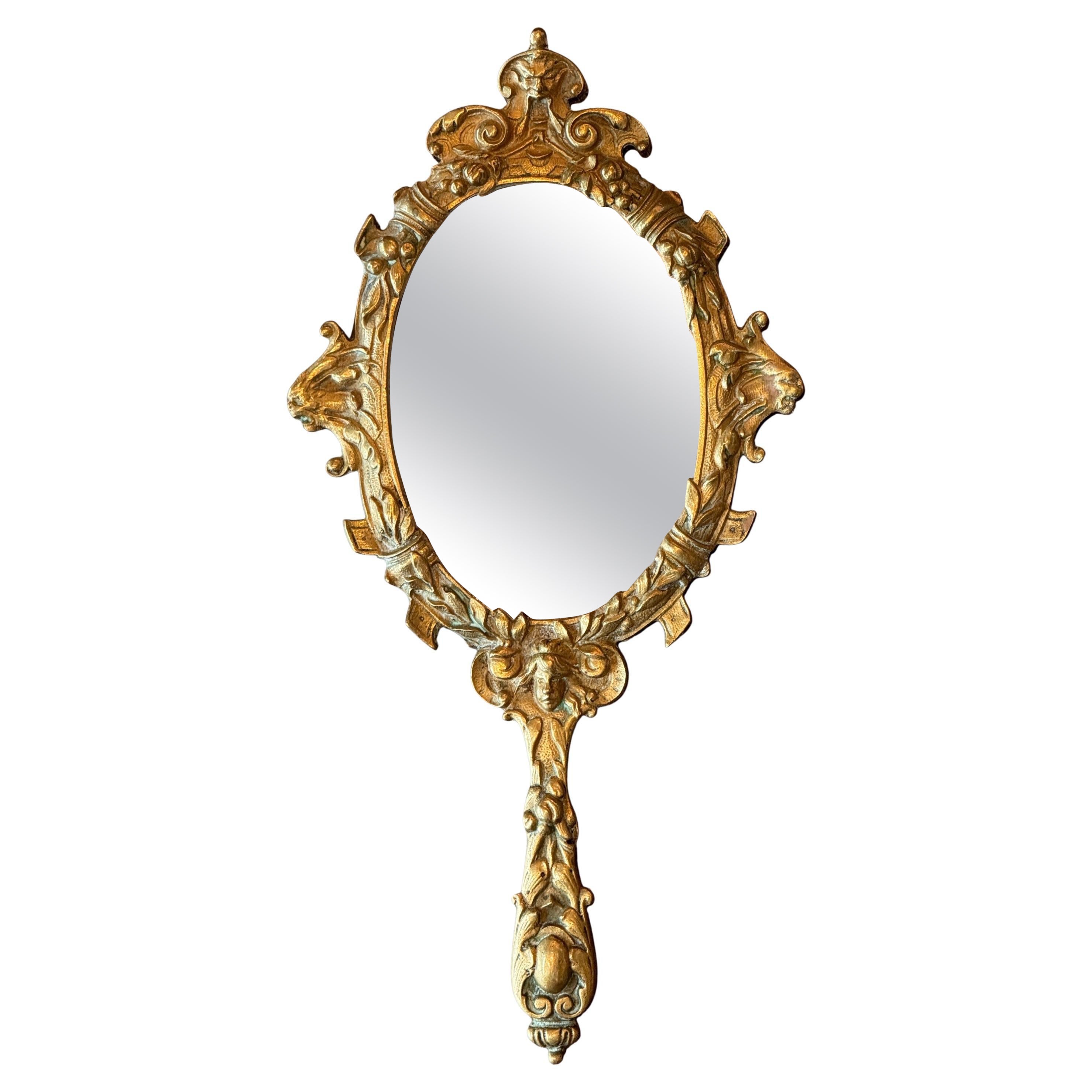 Miroir à main en laiton moulé orné de motifs figuratifs en vente