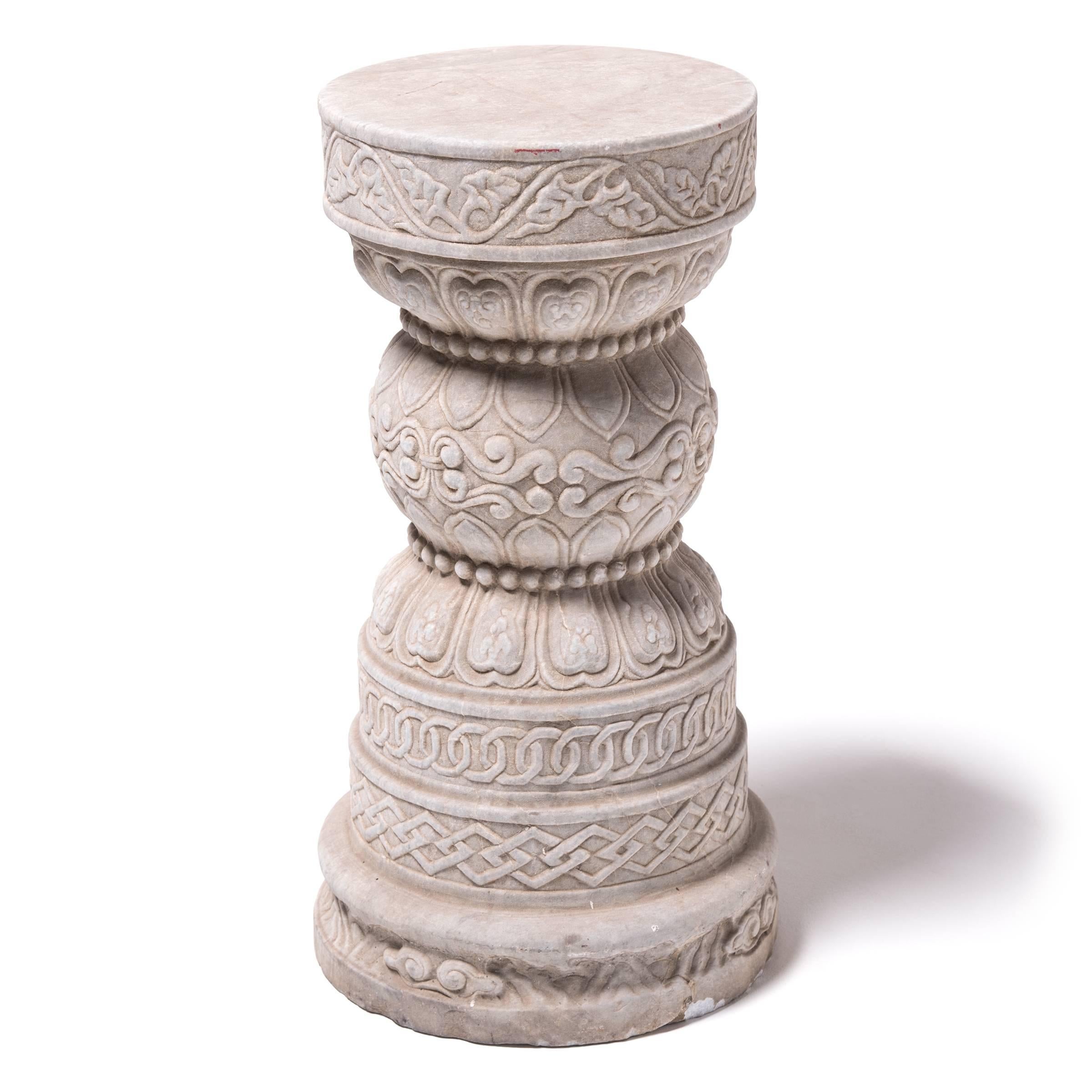Intricately carved from white marble with subtle natural veining, this kind of pedestal would have graced the garden of a courtly home in Southern China at the turn of the 19th century. Textured with carved geometric and botanical motifs, the