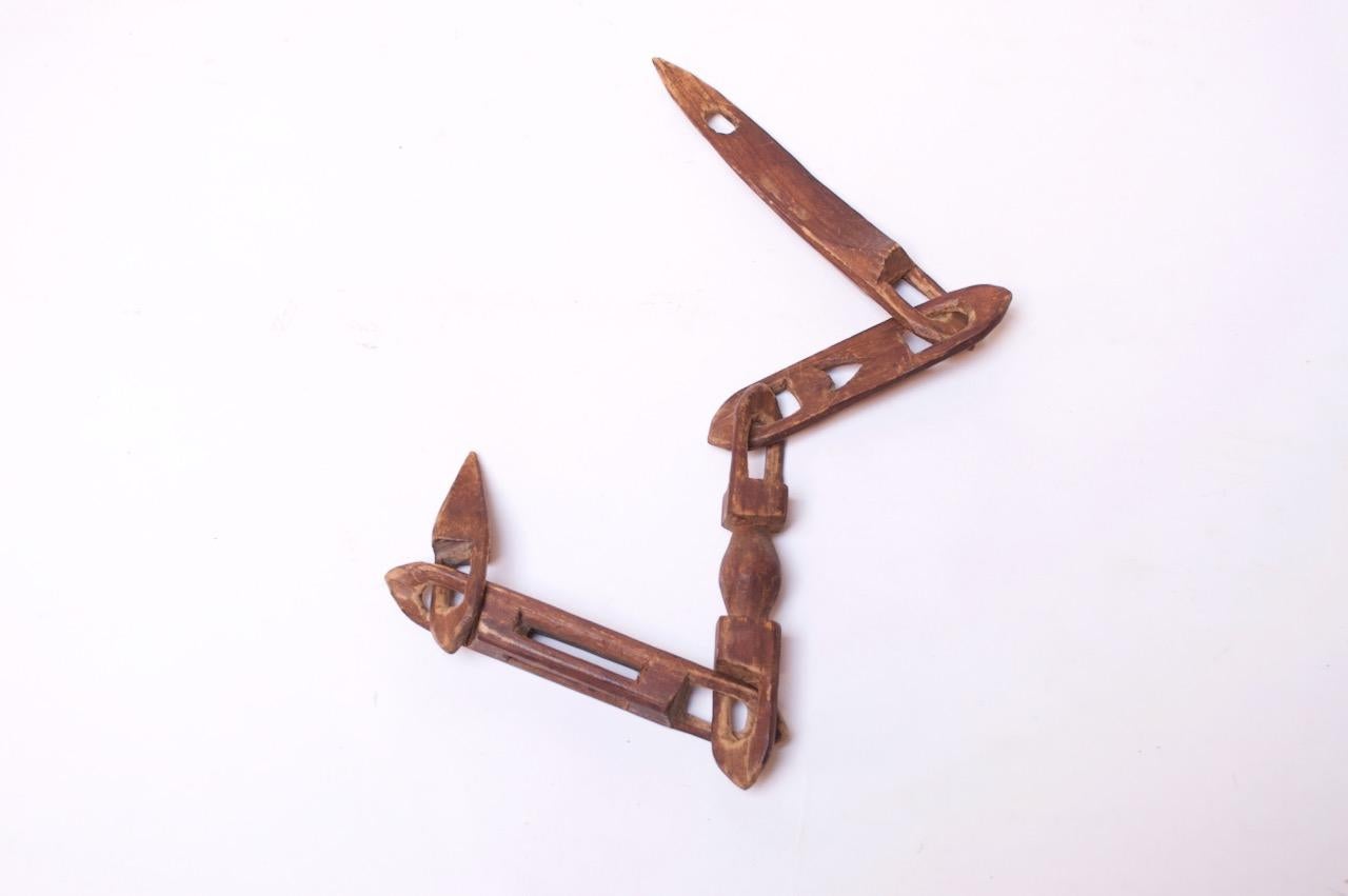 American whimsy chain whittled from one continuous piece of wood, circa early 20th century. The carvings on this piece are more technical and detailed than traditional 'chain link' examples. This particular artist played around with shapes and