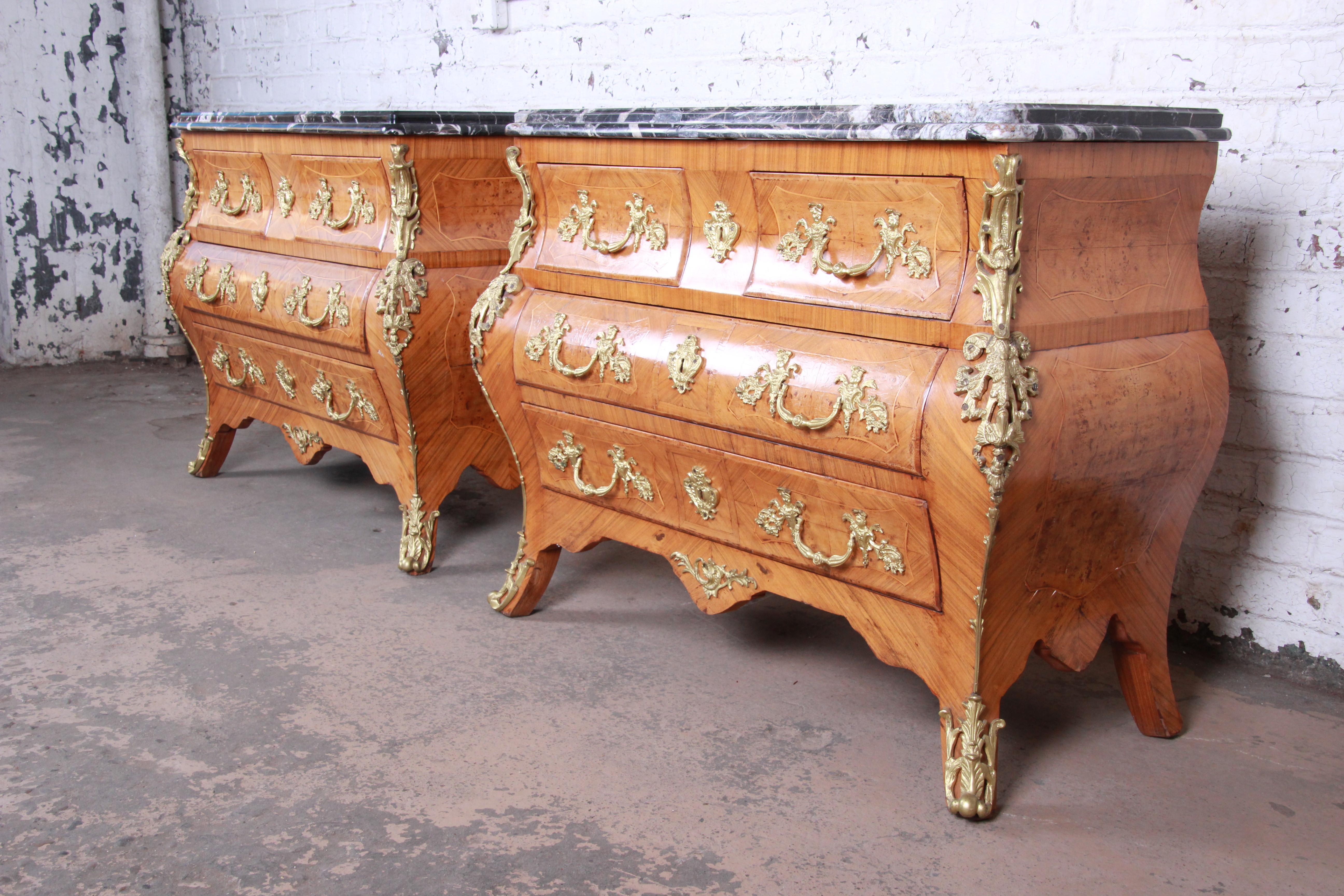 An exceptional pair of French Louis XV style mahogany bombay chests or commodes. The chests feature stunning mahogany wood grain with satinwood string inlays and inlaid burl wood. They have ornate mounted ormolu and incredible 1.75