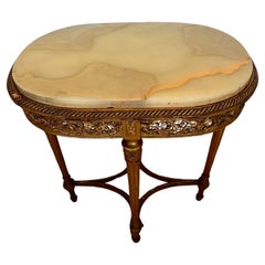 Mesa auxiliar ovalada de madera dorada estilo Luis XVI con tapa de mármol
