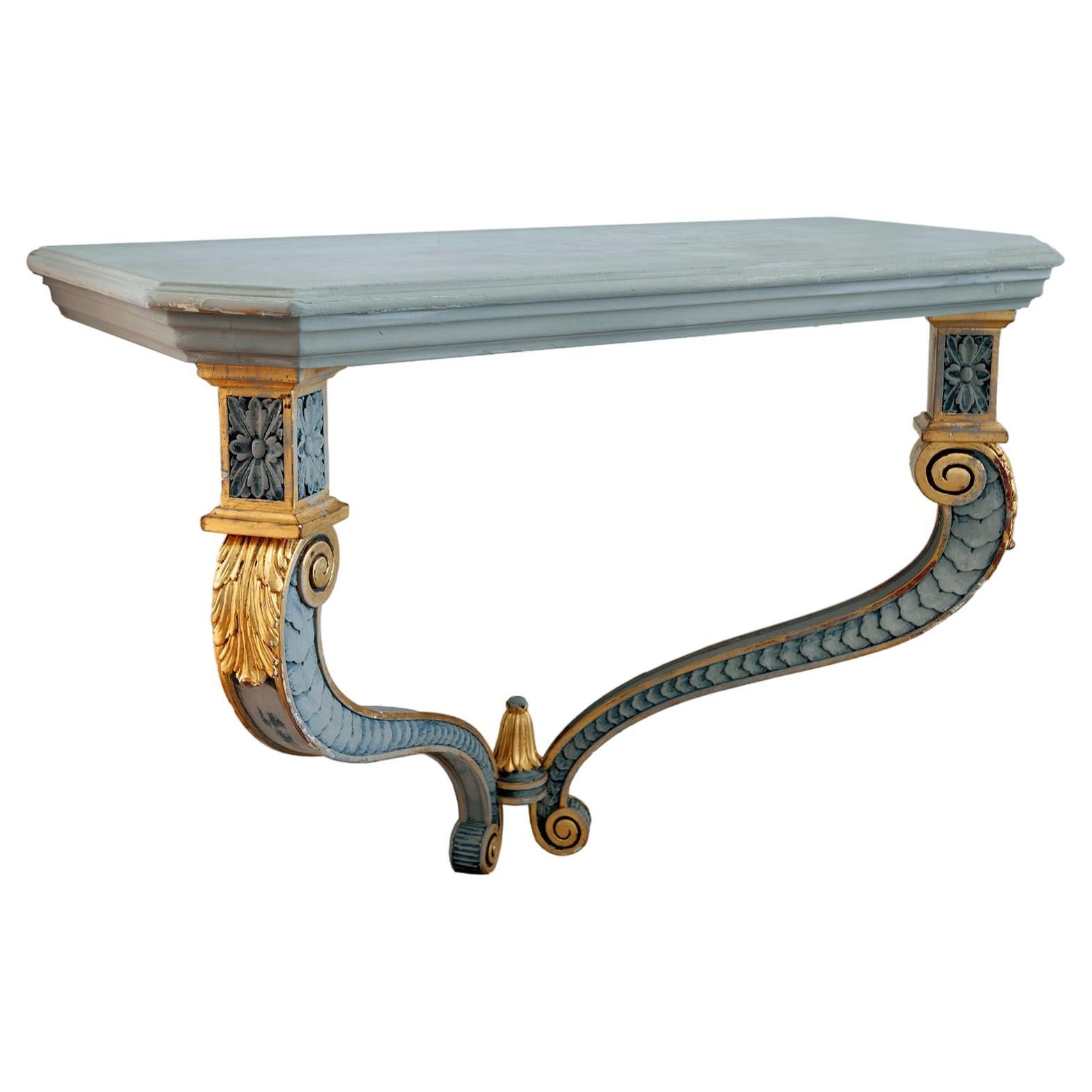 Gilt & carved hand-crafted 20th century Italian Renaissance Venetian style wall mounted console table, hand painted & carved with gilt accents.
The elaborately carved legs are accented with gilt & warm gray carving. The gilt trimmed legs meet at the