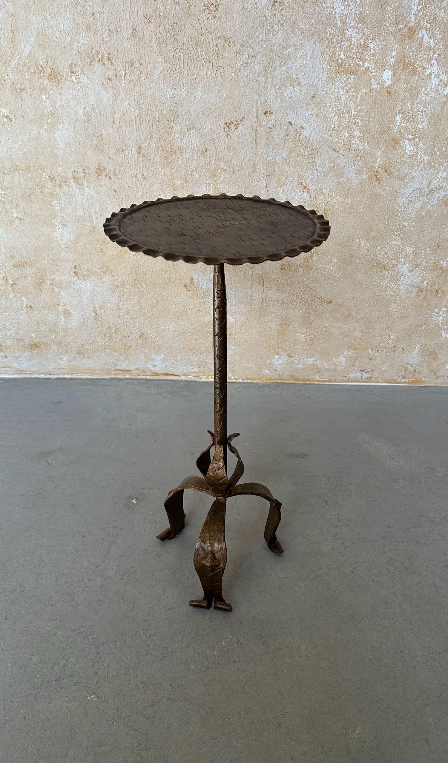 This intriguing Spanish iron and metal side table is based on a 1950s vintage design and was recently crafted by skilled artisans using traditional iron-working methods and techniques. Standing at 24 inches tall and 12 inches in diameter, the table