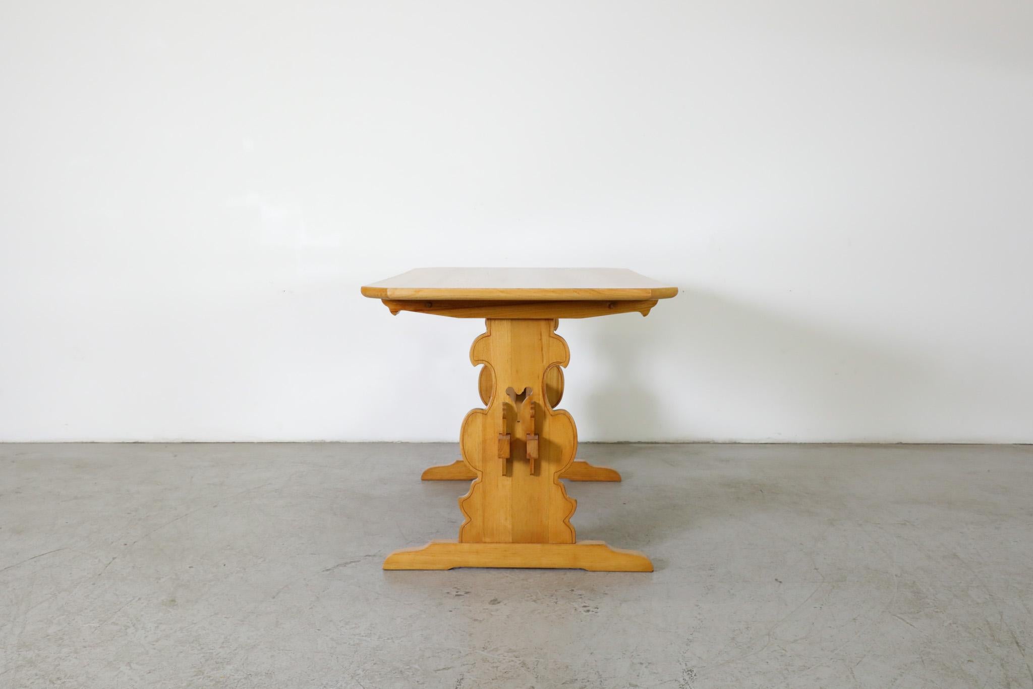 Mid-Century Tyrolean style carved Oak dining table with trestle base, clipped corners and ornately detailed carvings. An attractive and versatile table that can be used as in an entry way, desk or vanity. In original condition with visible wear