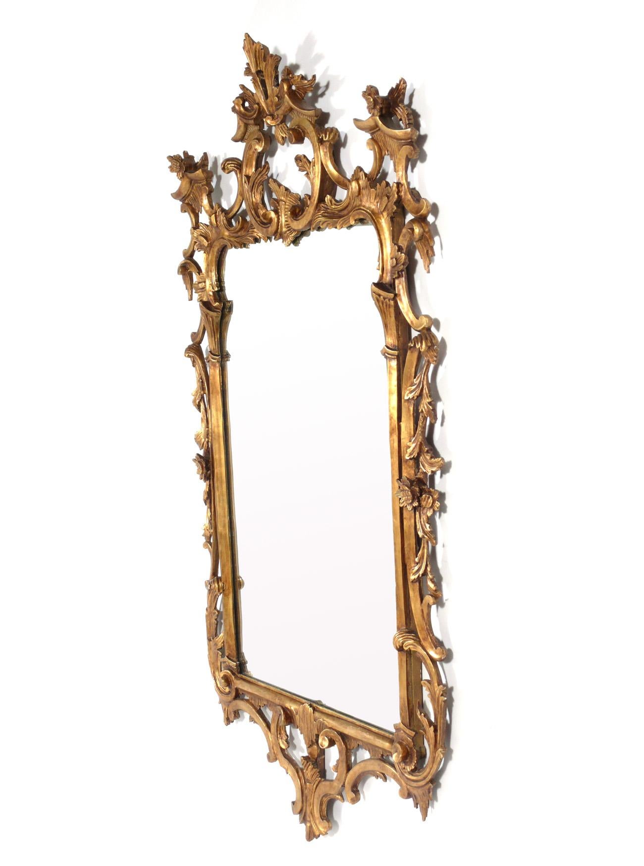 Ornate Italian gilt mirror, Italy, circa 1950s. Retains warm original patina to both the giltwood frame and the original mirrored glass. It measures an impressive 58