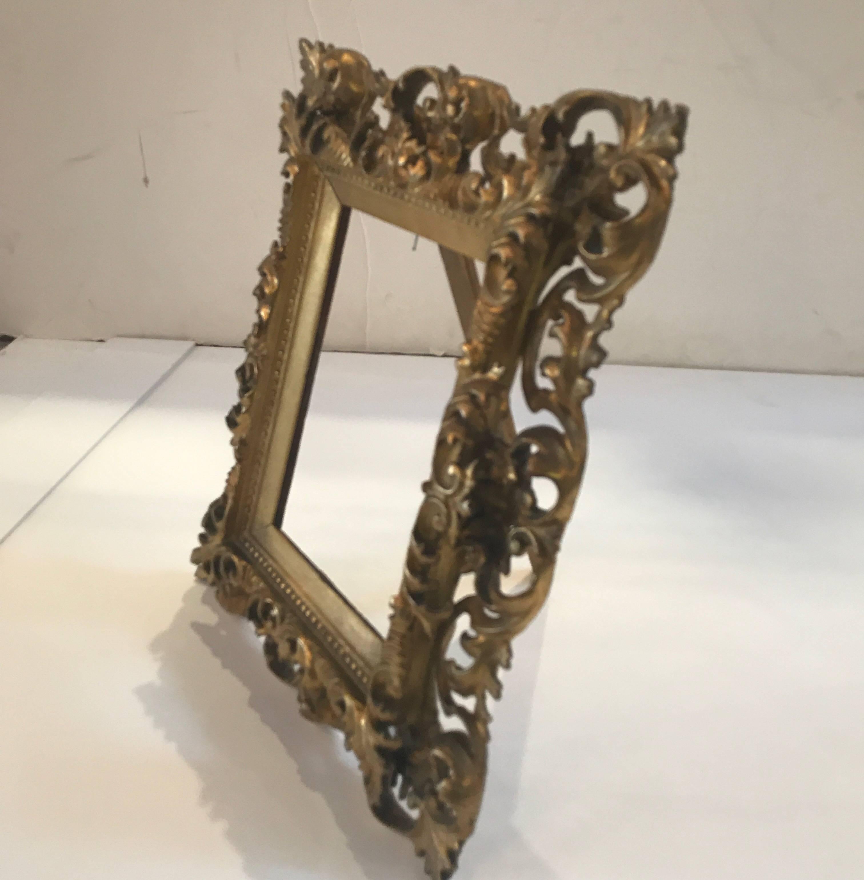 An Italian gilt over wood intricate reticulated frame. This frame with elaborate Rococo scrolling leaves all around. The frame can be fitted with glass for a picture frame or fitted with a small piece of art. This frame with elaborate Rococo