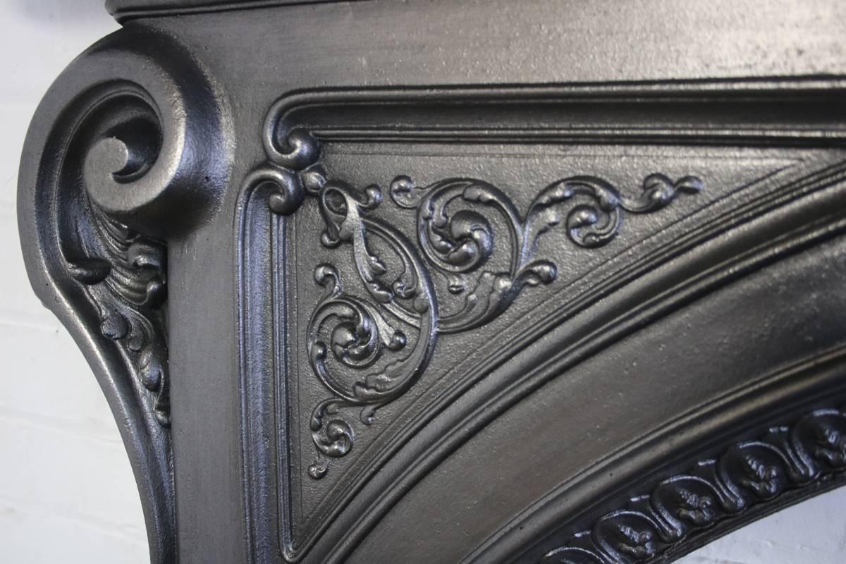 Ornate mid-19th century Victorian cast iron fire surround with arched aperture, circa 1870. 

Finished in traditional black grate polish giving a gun metal sheen.