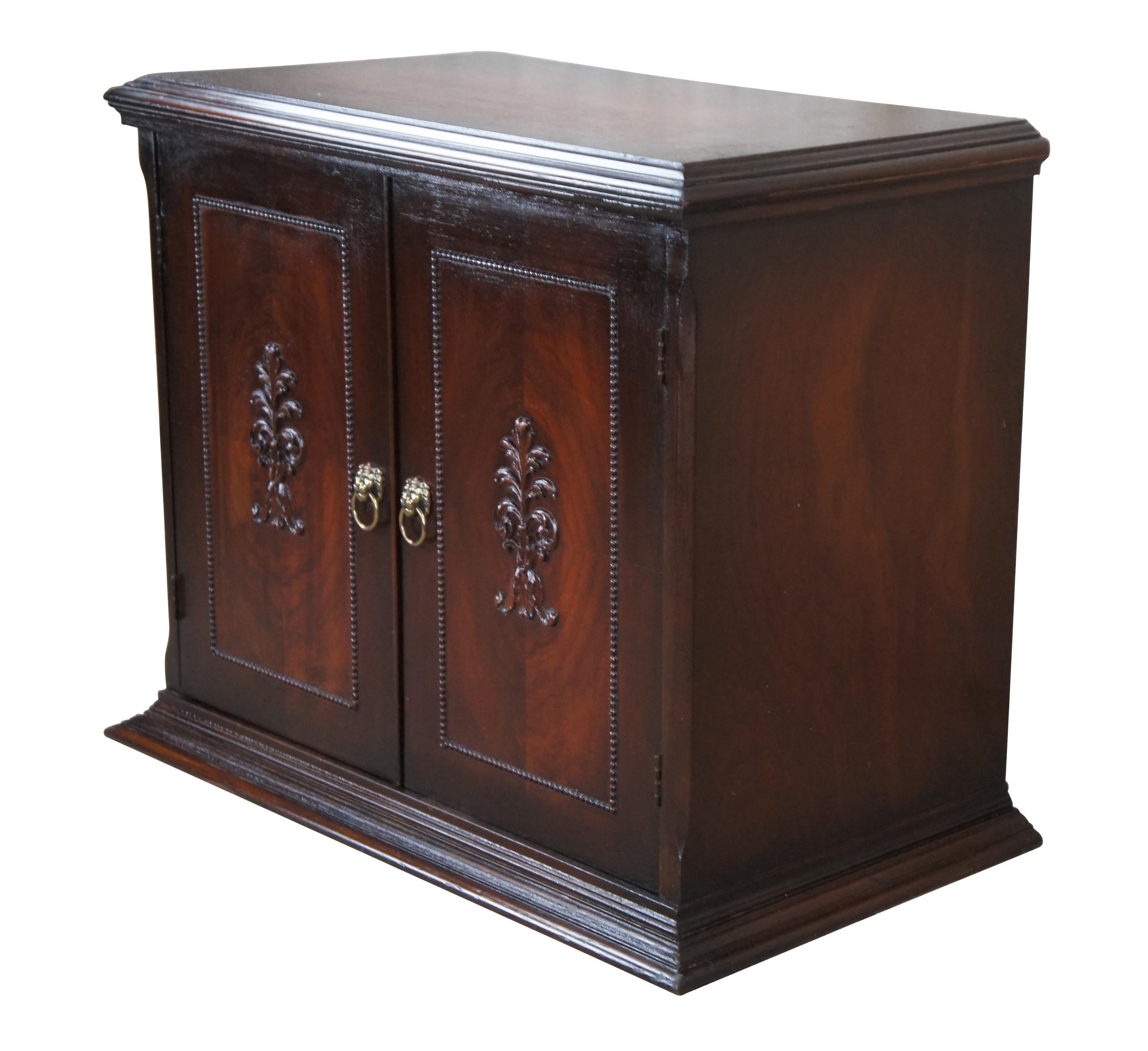1940s vintage 2 door cabinet.  Made from walnut with matchbook doors featuring beaded trim and acanthus carved center.  The cabinet opens via lion head knocker pulls to a storage area with s helf.  Vented along back left.  This cabinet was