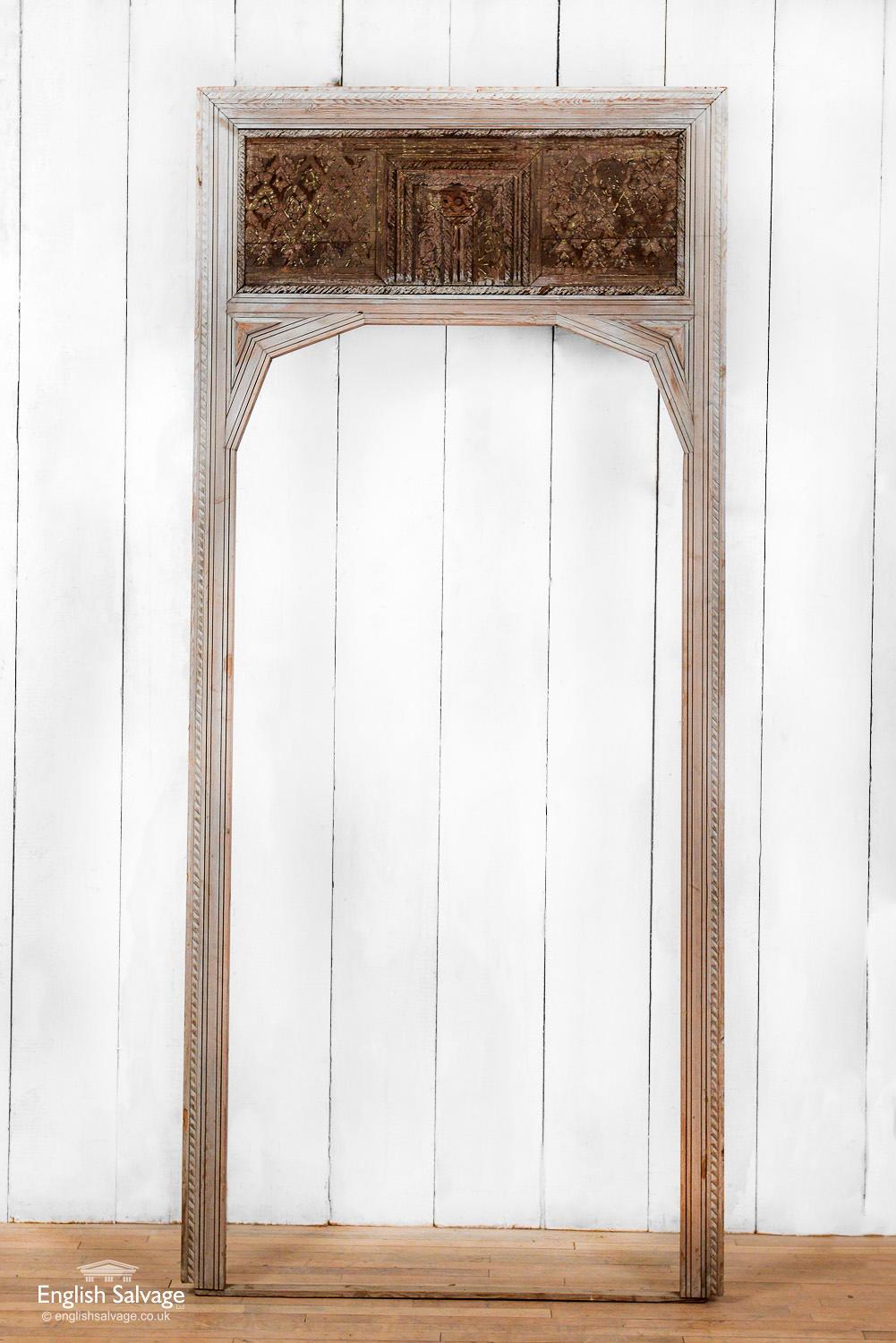 Stripped pine frame, salvaged from Morocco, with an older looking ornately carved wooden panel top light. The opening is 91cm wide x 194.2cm high (168cm high to the start of the angled arch). Overall size of frame stated below. Few dings to edges.