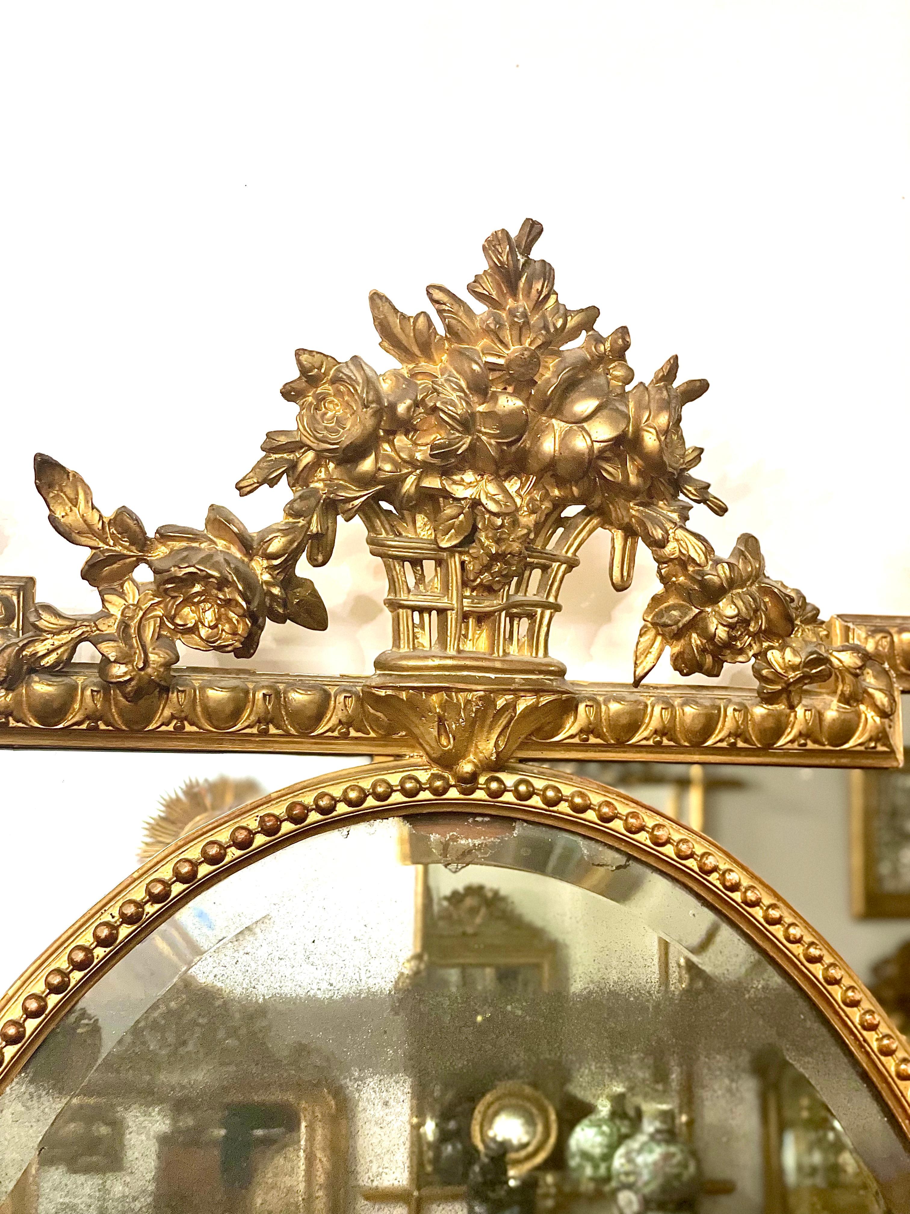 A gorgeous and imposing Napoleon III period wall mirror, with parcloses, in moulded, carved stucco and gilded wood. The haut-relief outer frame is decorated with stepped corners, egg-and-dart mouldings and ornate decoration to three sides, while the