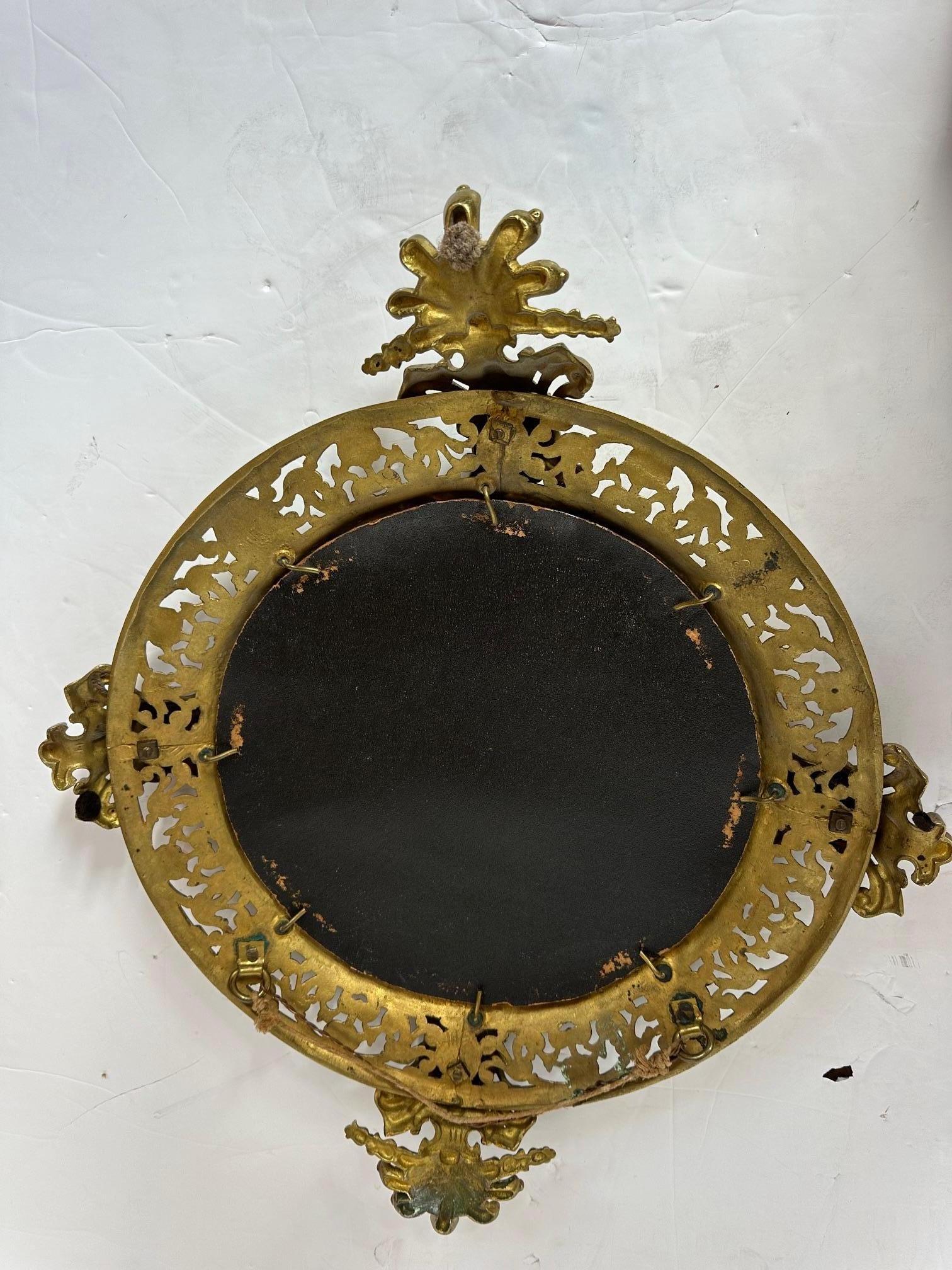 Paire de miroirs biseautés italiens avec cadres figuratifs en laiton.

