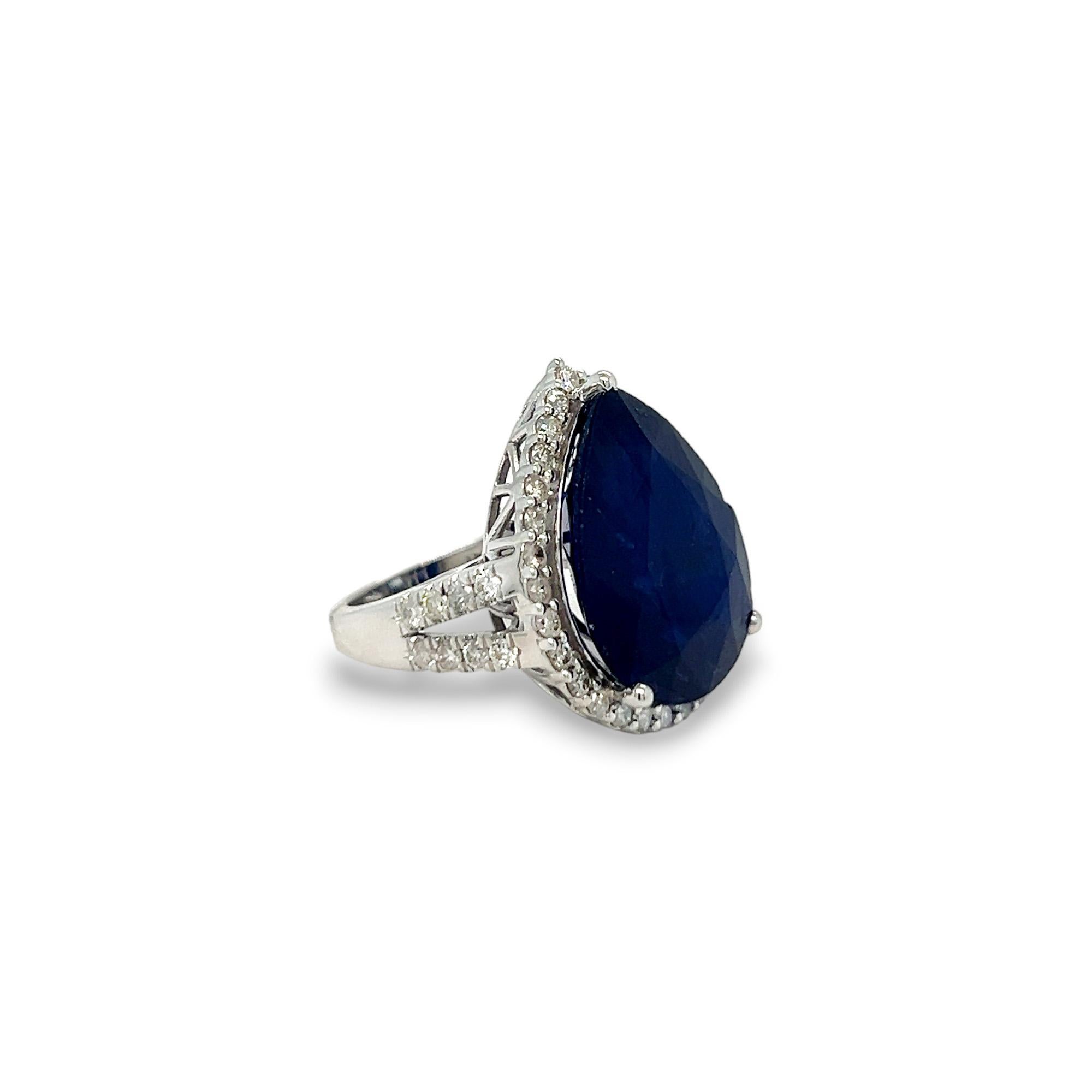 This gorgeous statement ring features a beautiful 20.68 carat pear shaped sapphire center stone and a halo of round diamonds. The side diamonds on the band as well as those that comprise the halo are 1.26 carats total weight, H/I color, and SI
