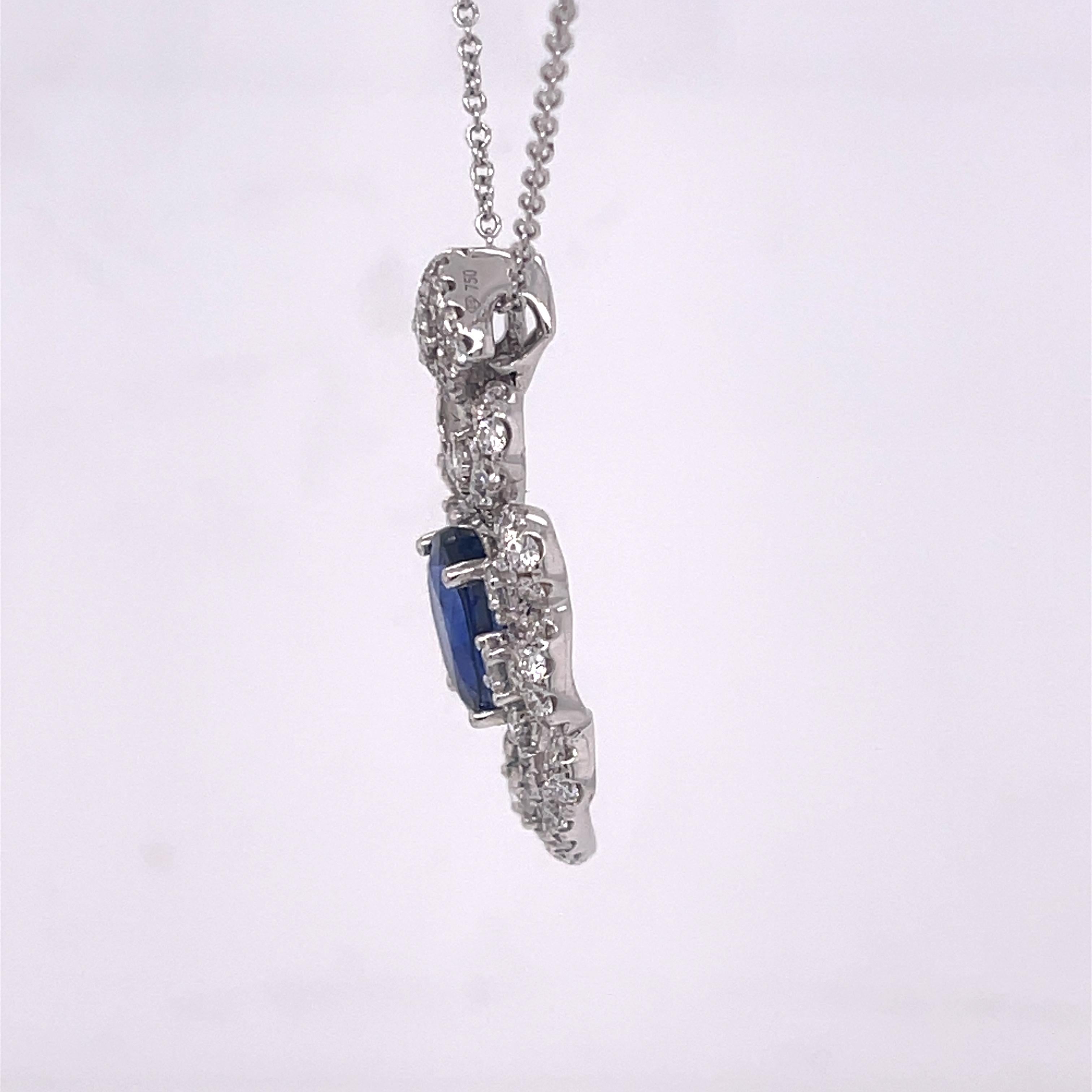 Ornate pendant necklace featuring an oval 3.04ct sapphire and 1.37ctw of diamonds. Set in 18K white gold and on a 18 inch chain. Stamped 18K 750 D1.37 S3.04. Pendant measures 1.25