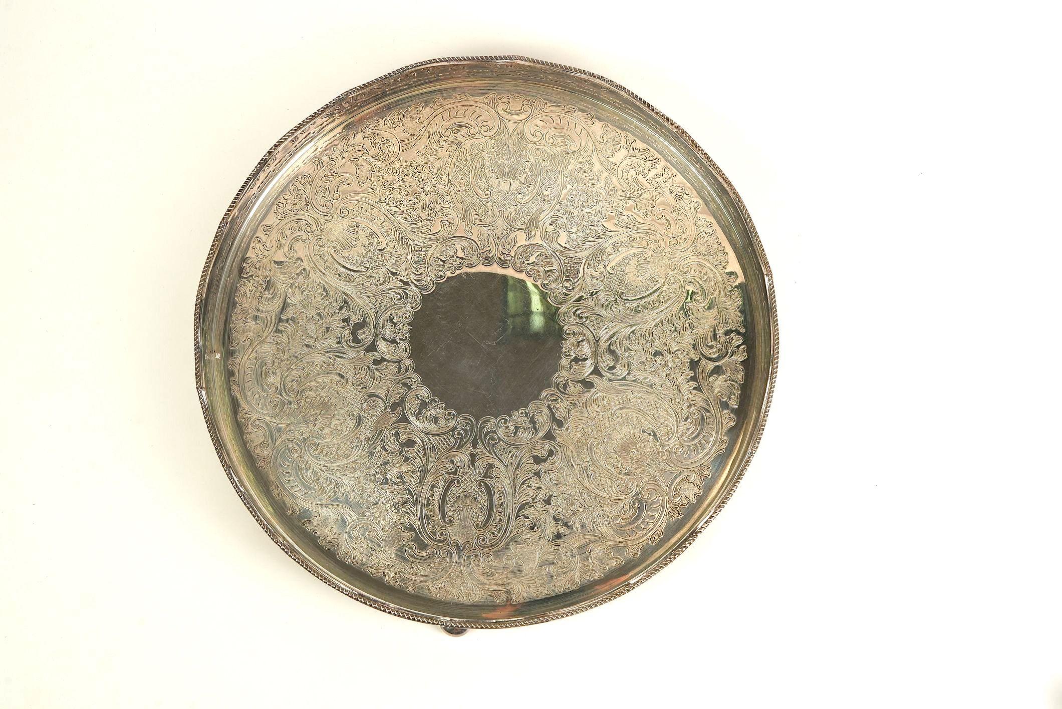 This antique silver-plated tray is a standout piece thanks to its intricate, hand-engraved scrollwork that covers nearly the entire surface. The swirling floral patterns are exceptionally detailed — not stamped, but likely etched by hand, lending