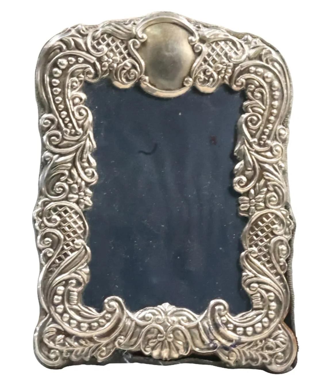 20th century sterling silver picture frame with ornate decorative border. 
