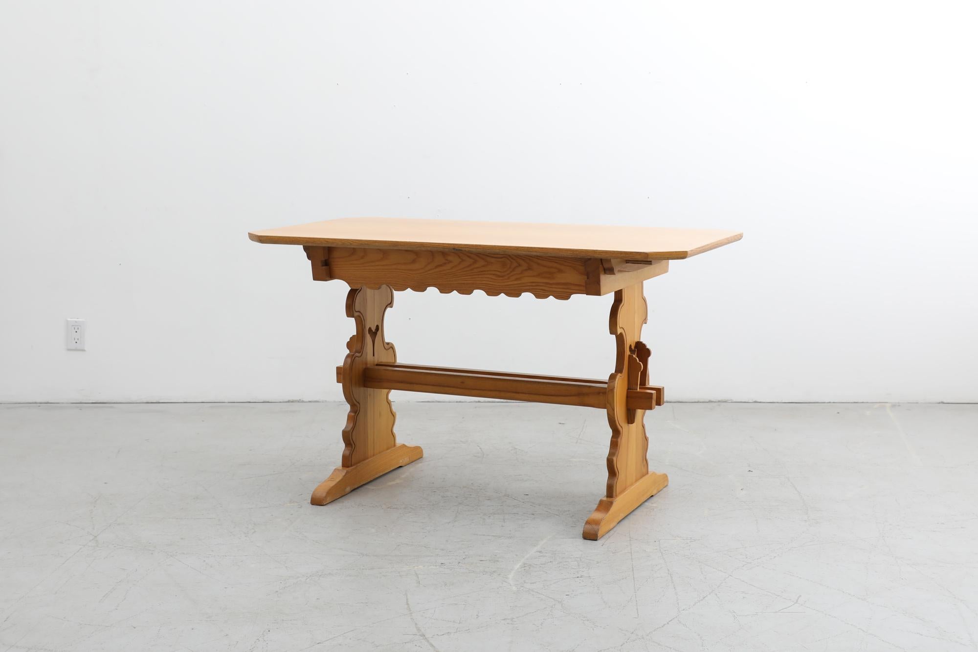 Ornately carved table in Tyrolean style with drawer and trestle base. Originally intended as a dining table but can be used as an entry table, desk or vanity. In original condition with visible wear consistent with its age and use. 3 available in