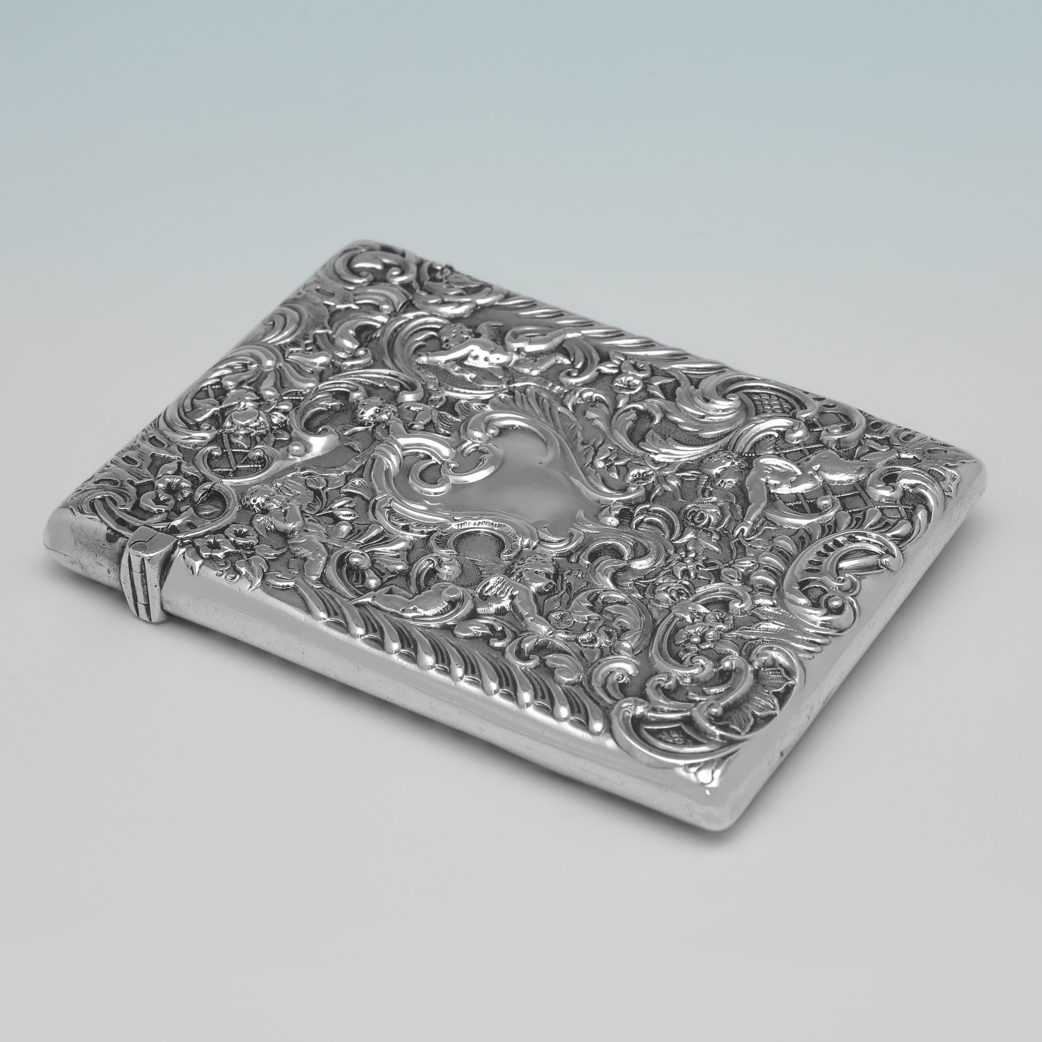 A stunning example of late 19th-century craftsmanship, this antique sterling silver calling card case was made in 1895 by the renowned London silversmith William Comyns. Finely cast in high-relief repoussé, the case features an intricate Rococo