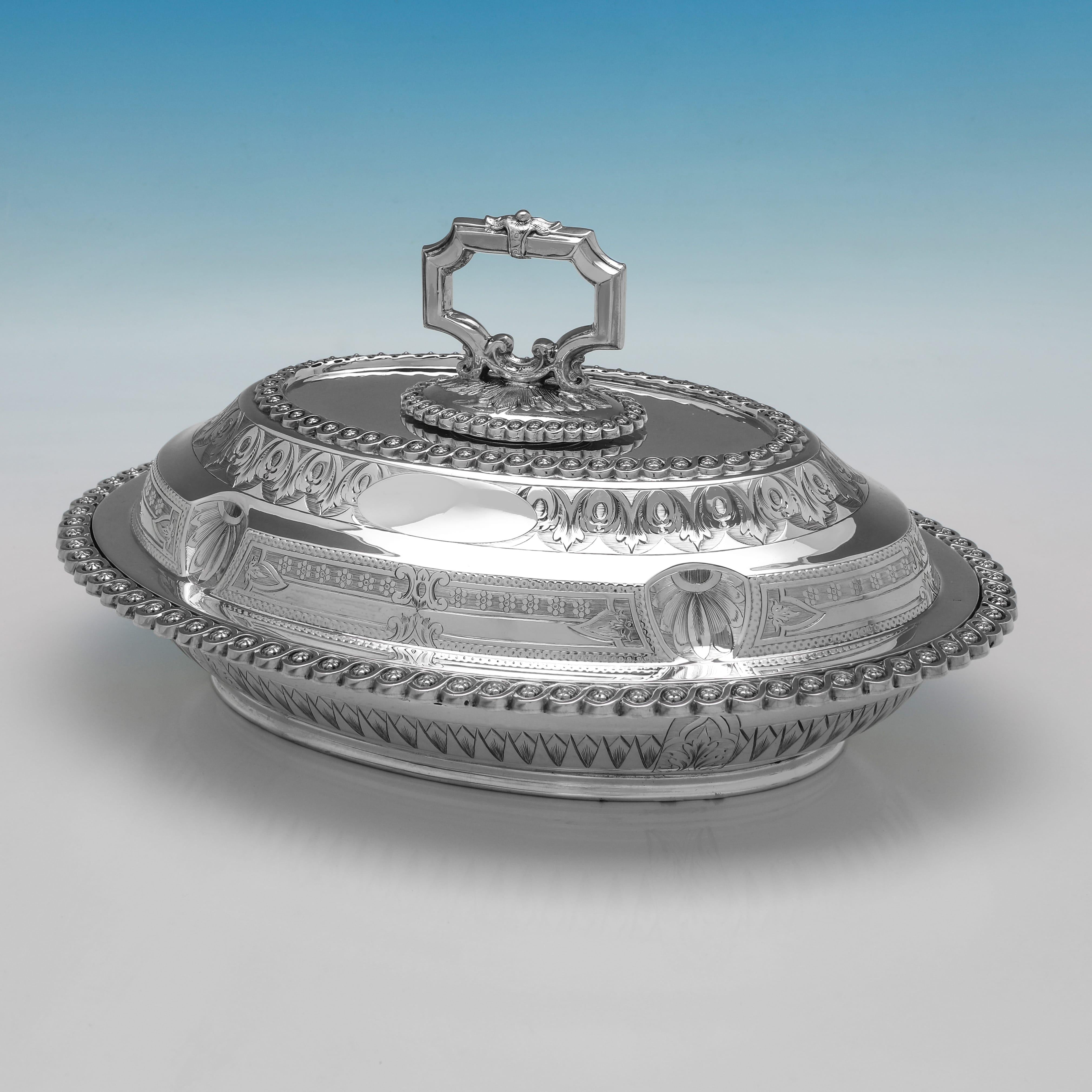 Hallmarked in Sheffield in 1874 by James Dixon 
Sons this ornate Victorian sterling silver entrée dish is of an oval form with a domed, reversible lid and a removable handle. The body and lid are decorated with repoussé and chased foliate