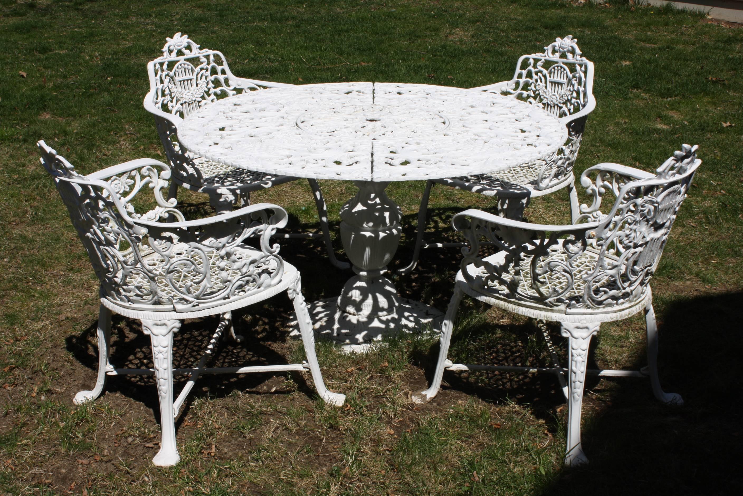 Wonderful ornate Victorian style garden dining set comprising a table and four armchairs. The set is made of cast aluminum so it is light and easy to move, and will not rust (this set has none of the care and maintenance associated with cast iron).