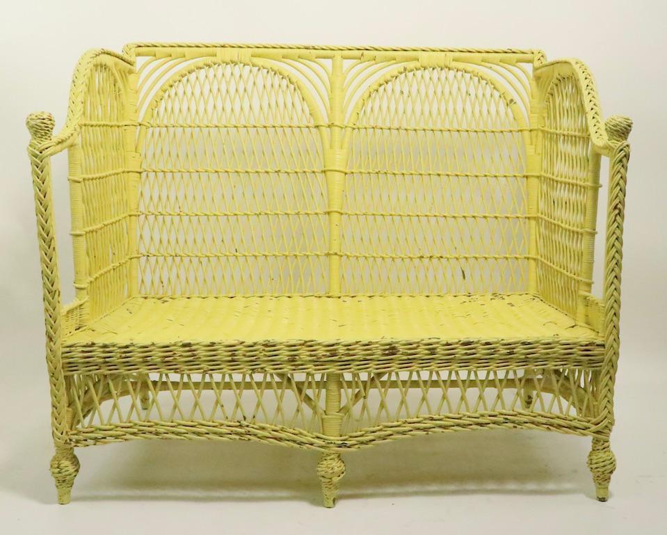 Ornate Victorian wicker settee, loveseat sofa, attributed to Heywood Brothers Company. This example is in very good condition, sturdy, solid and ready to use. It shows some cosmetic wear, scuffs etc, normal and consistent with age, it is currently