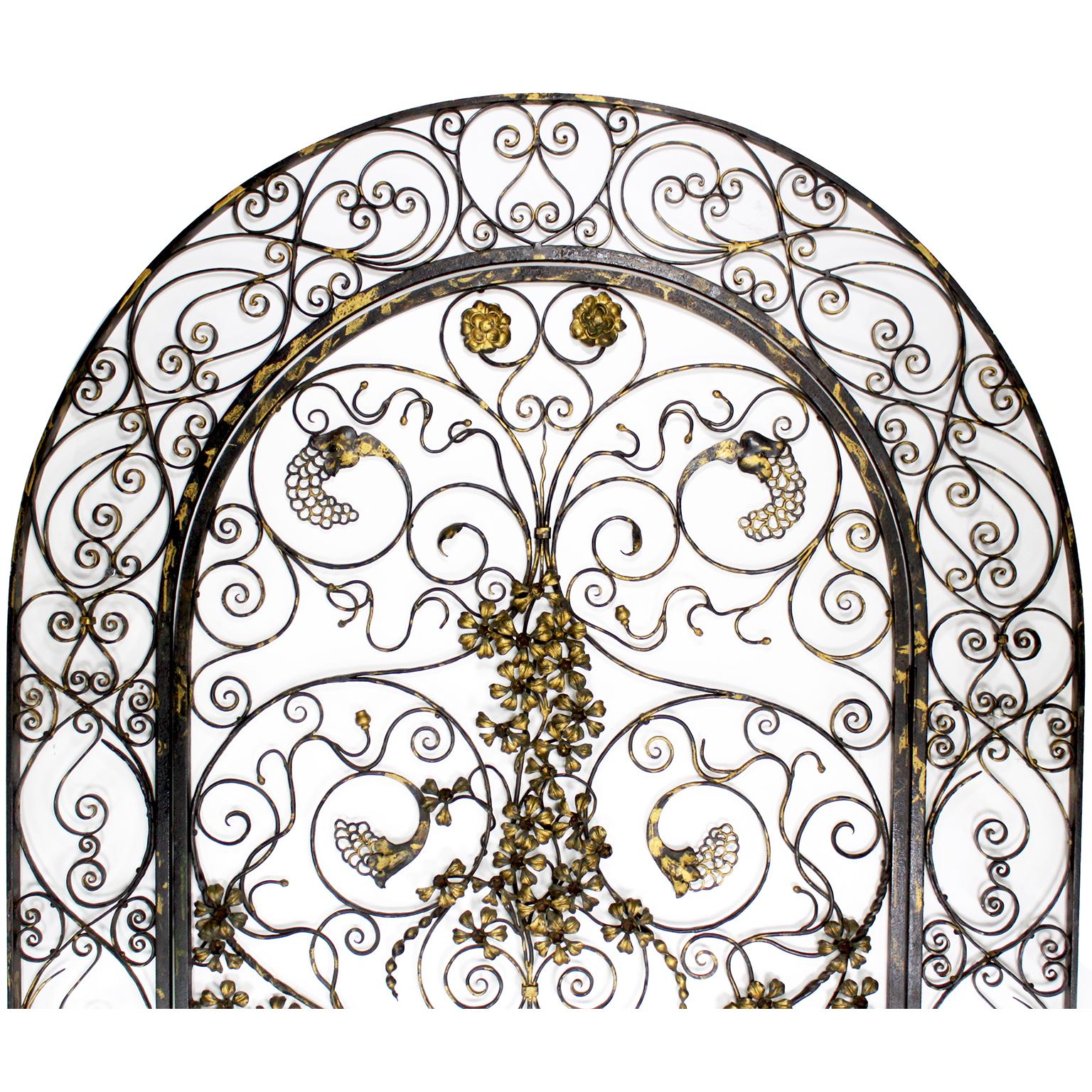 A Fine and Rare Ornate 20th Century Wrought Iron and Parcel-Gilt Figural Entry or Wine-Cellar Gate in the manner of Edgar Brandt (French, 1880–1960). The intricately designed Art Deco-Style single-door domed frame features scrolled ornamentation,