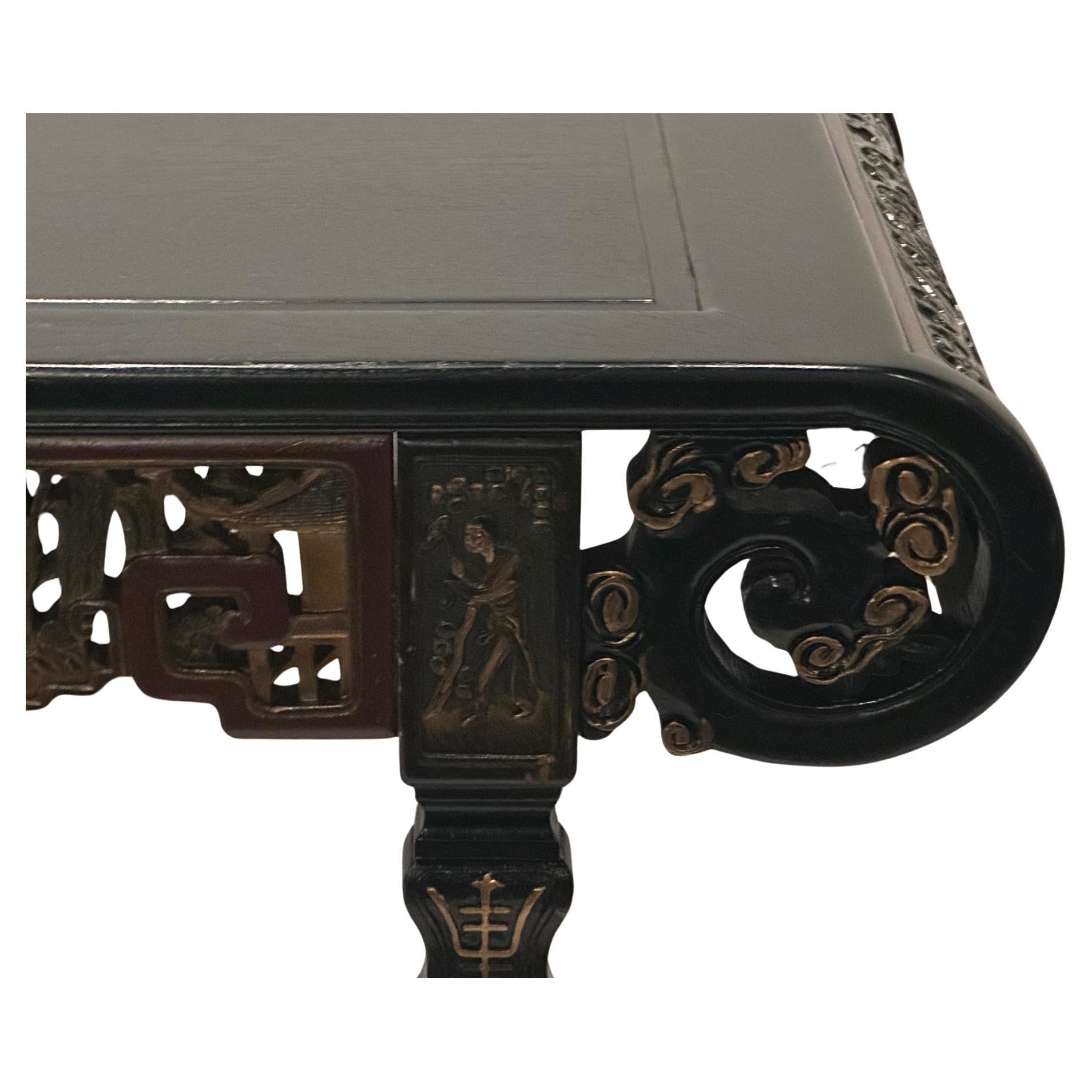 Gorgeous ornately carved antique ebonized center table having glistening burgundy and gold highlights.